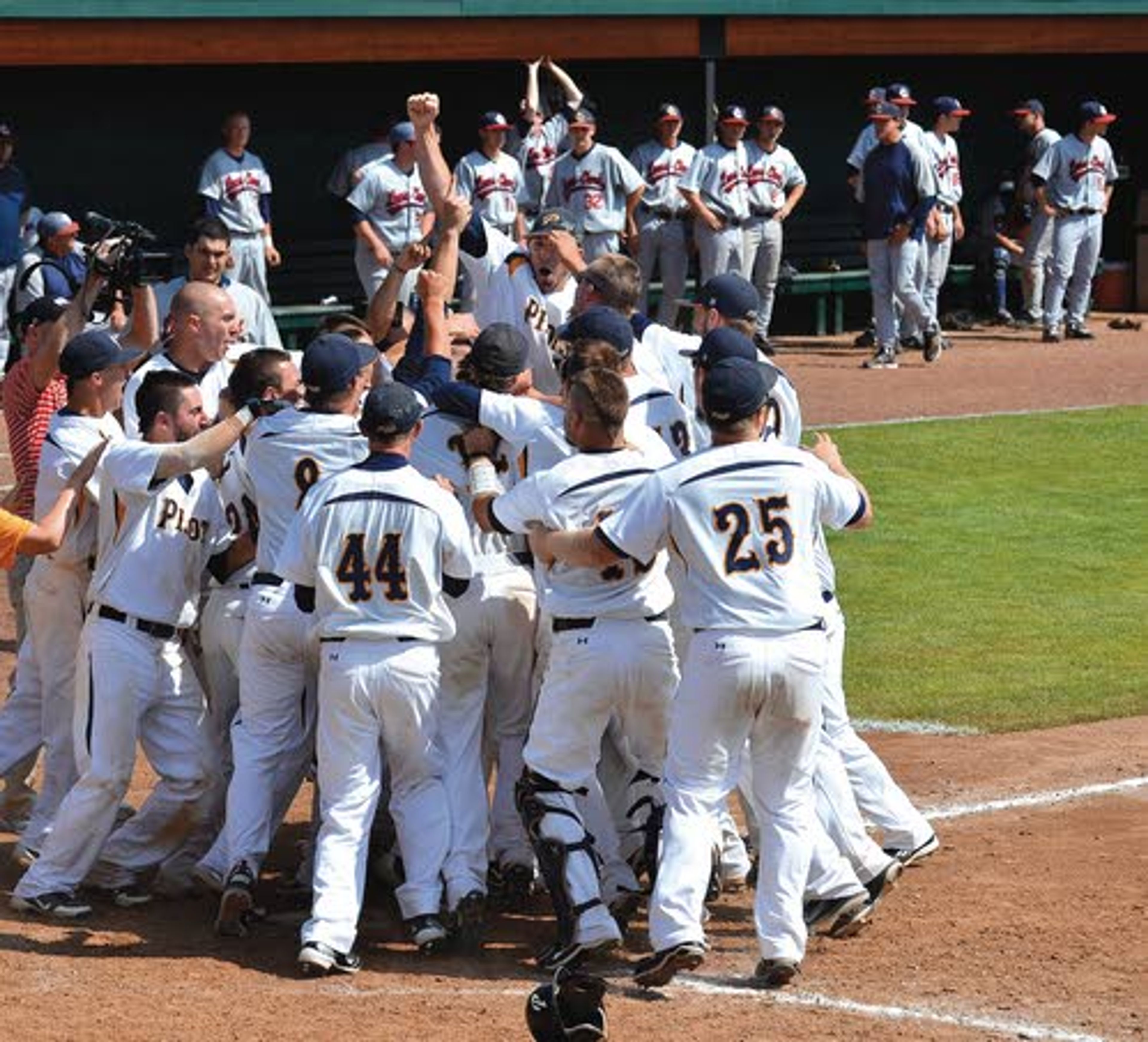 ABOVE RIGHT: LSU Shreveport third baseman Devin Greco scampers home after hitting a walk-off grand slam home run in the bottom of the ninth inning to help the Pilots beat Lewis-Clark State 7-3. ABOVE: Greco’s teammates envelop him as they celebrate their Game 10 victory Monday afternoon.