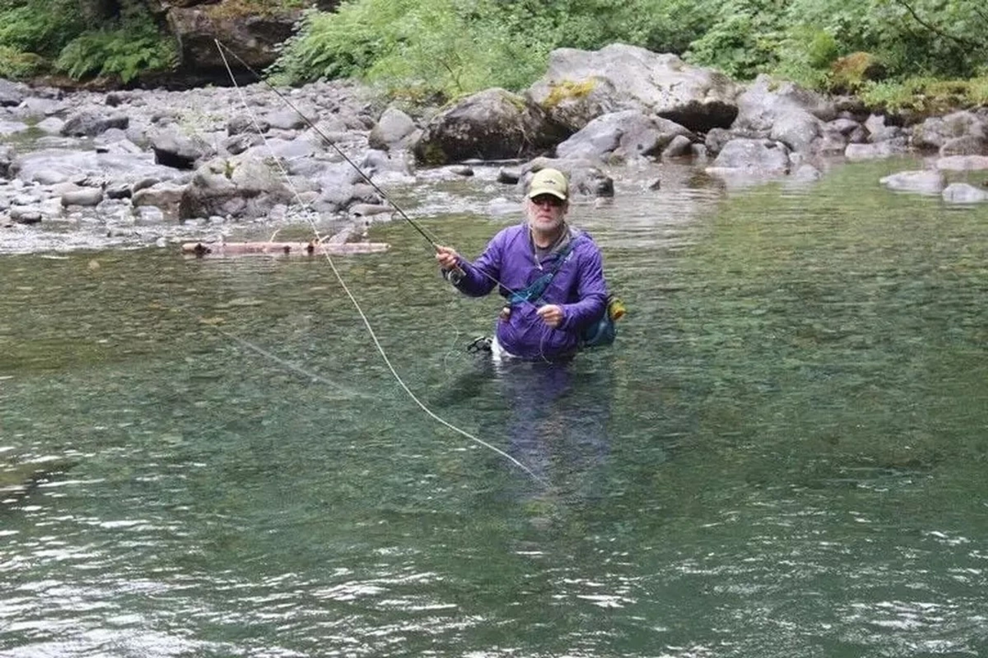 Steve Duda casts into the pool of a stream in the Cascade mountains.