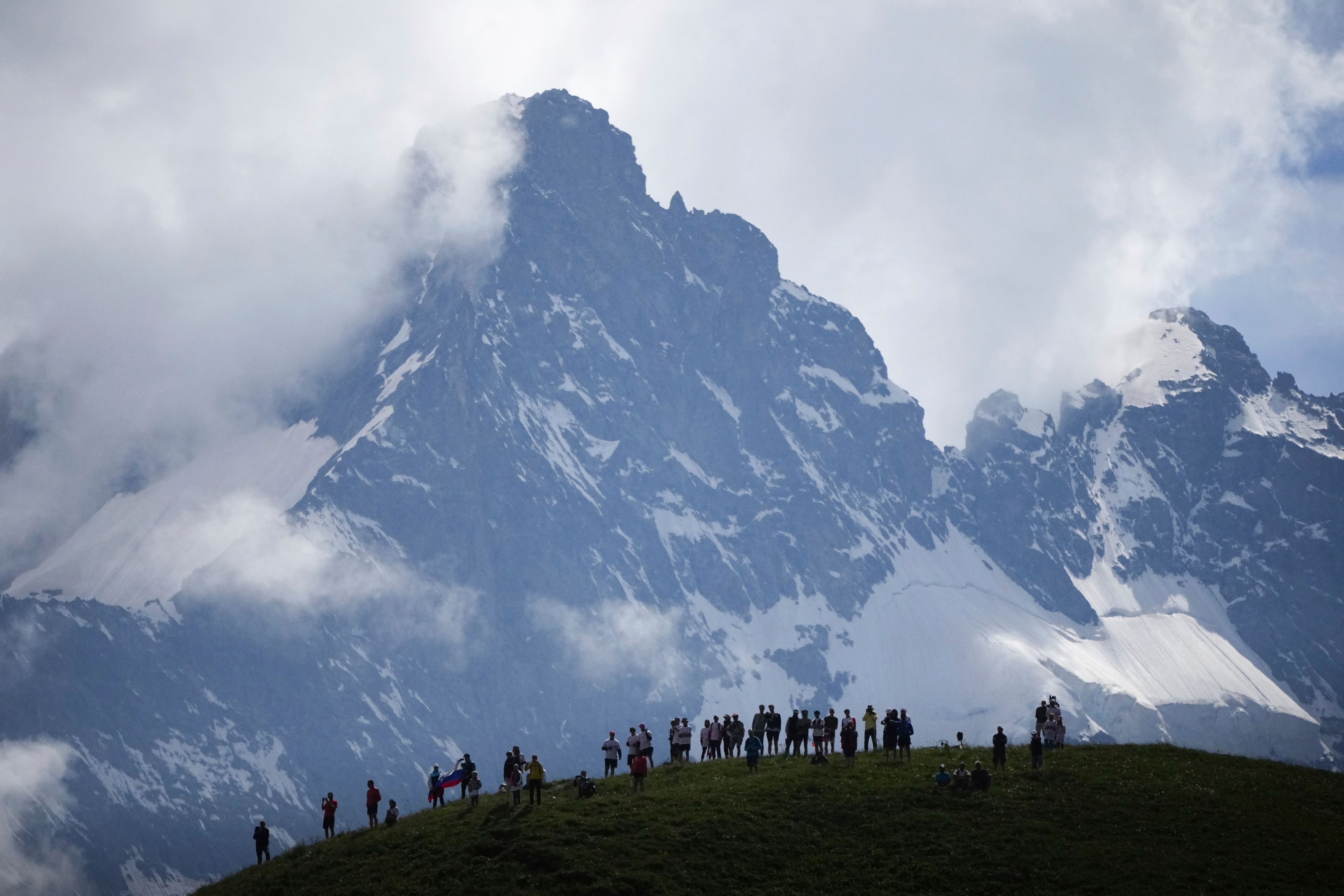 Spectators wait the riders to pass in the Col du Galibier during the fourth stage of the Tour de France cycling race over 139.6 kilometers (86.7 miles) with start in Pinerolo, Italy and finish in Valloire, France, Tuesday, July 2, 2024. (AP Photo/Daniel Cole)