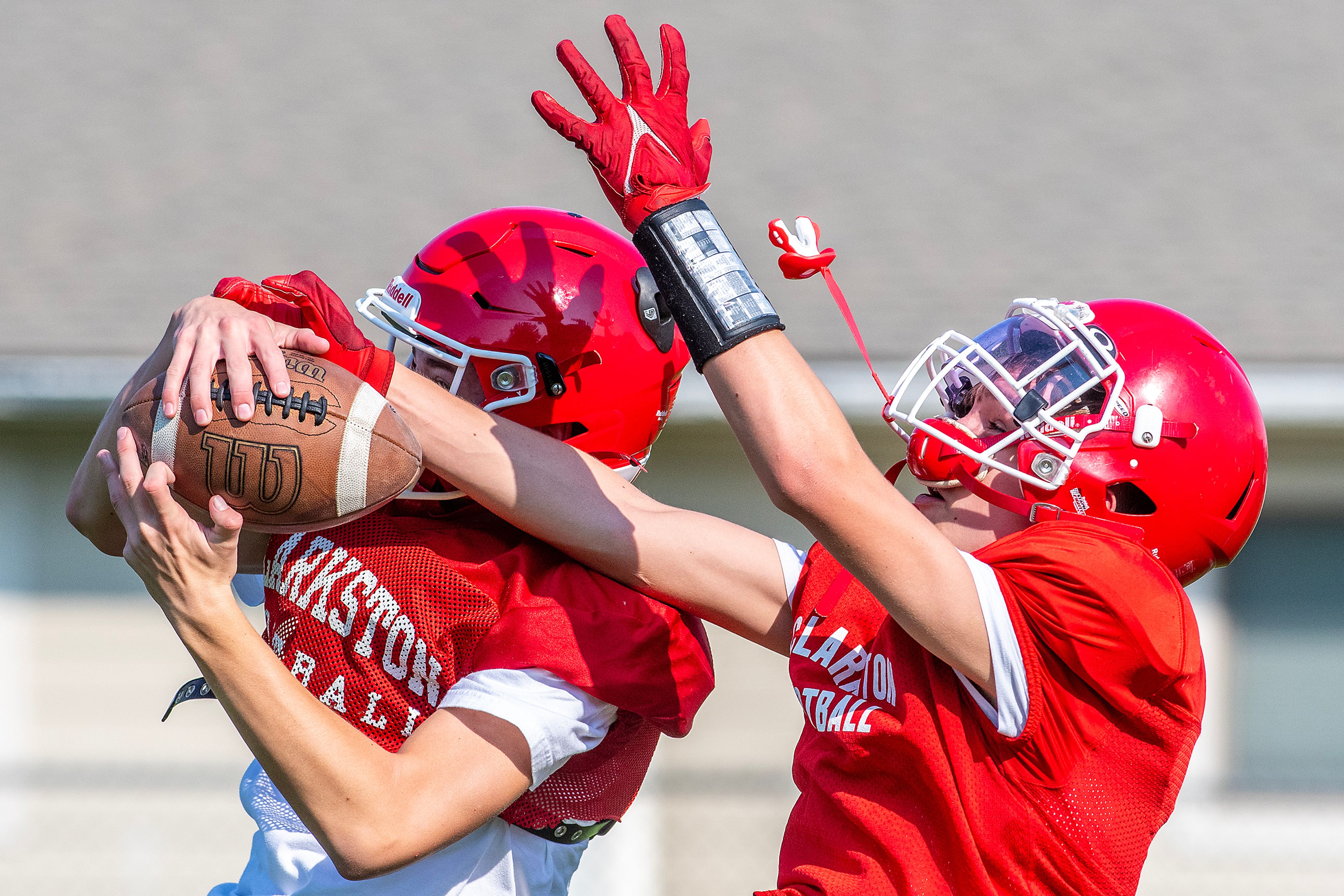 Clarkston players pull down a catch at football practice Tuesday in Clarkston.