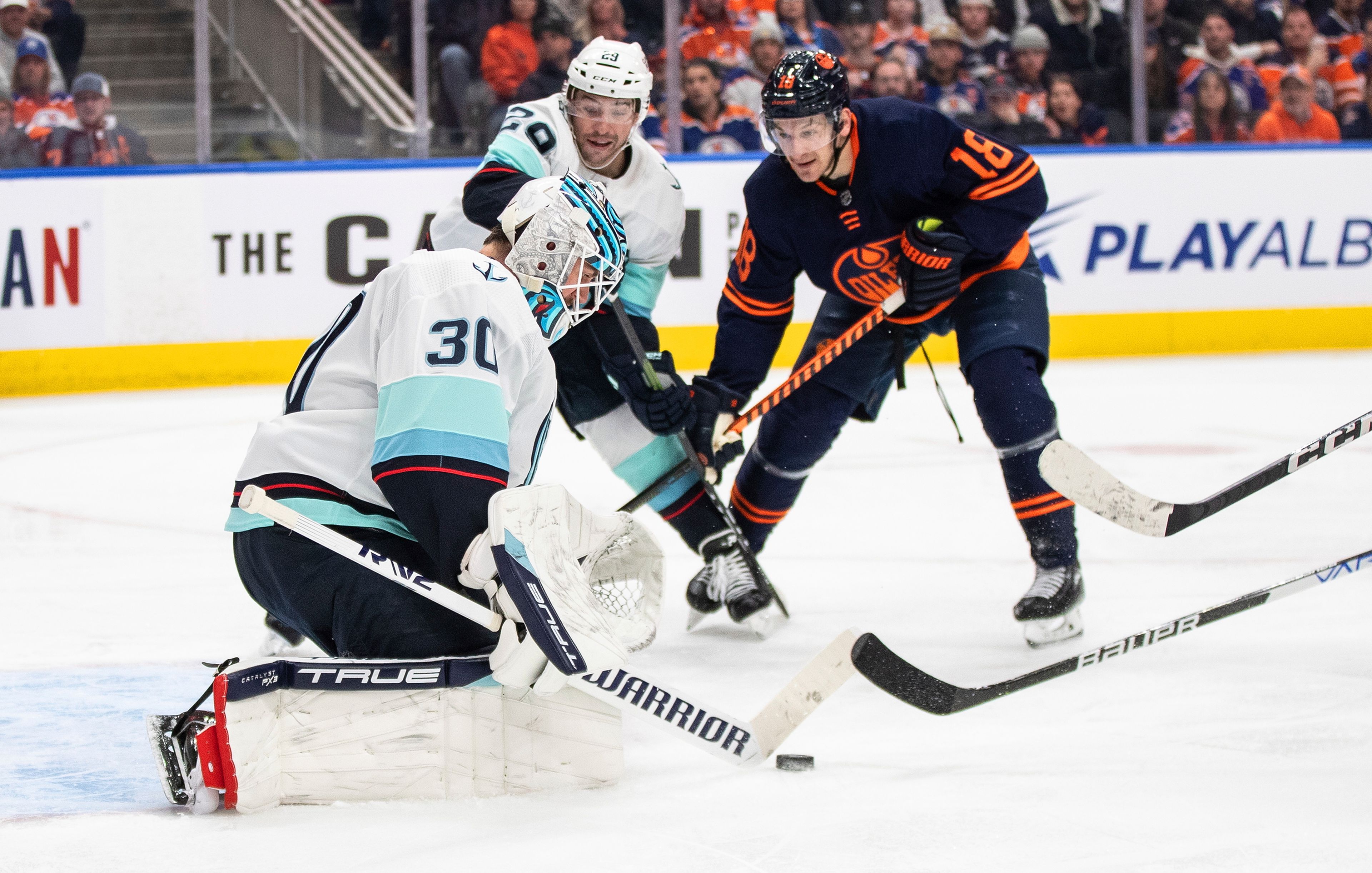 Seattle Kraken goalie Martin Jones (30) makes a save as Edmonton Oilers' Zach Hyman (18) and Vince Dunn (29) look for the rebound during the second period of an NHL hockey game Tuesday, Jan. 17, 2023, in Edmonton, Alberta. (Jason Franson/The Canadian Press via AP)