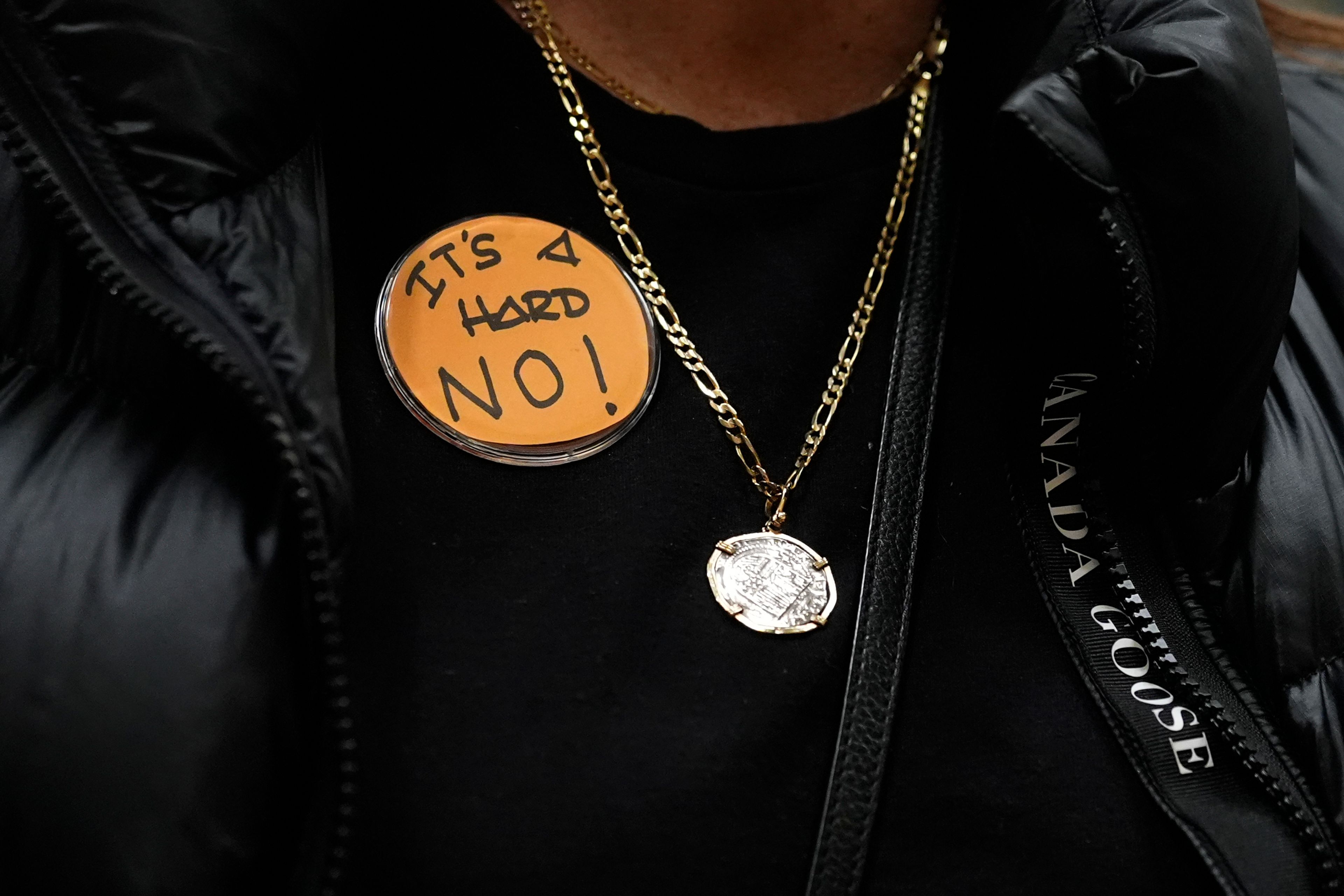 Boeing employee Gina Forbush wears an pin saying "IT'S A HARD NO!" while listening to the announcement that union members voted to reject a new contract offer from the company, Wednesday, Oct. 23, 2024, at Seattle Union Hall in Seattle. (AP Photo/Lindsey Wasson)