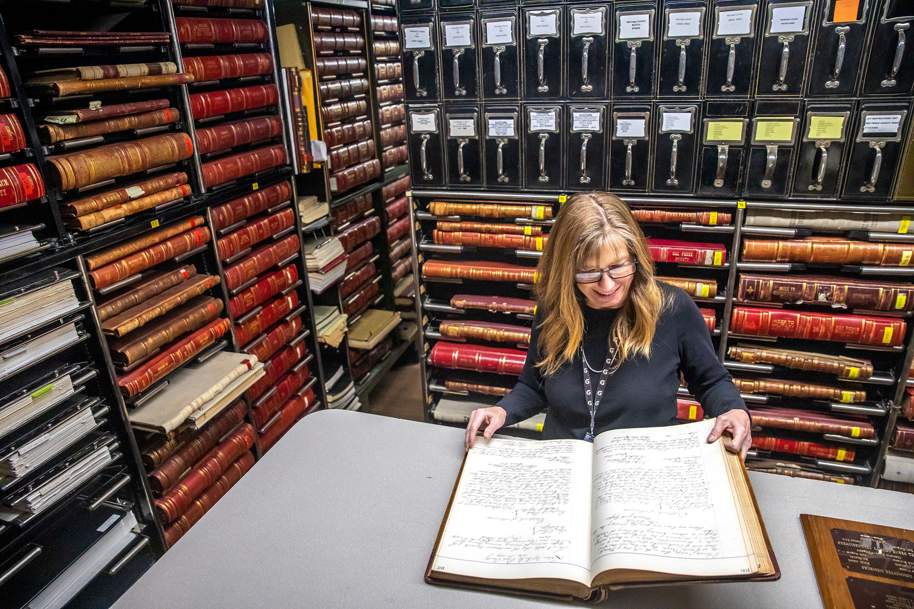 Patty Weeks looks through one of the leather-bound books that will be put in the new courthouse Friday at the Nez Perce County Courthouse in Lewiston.