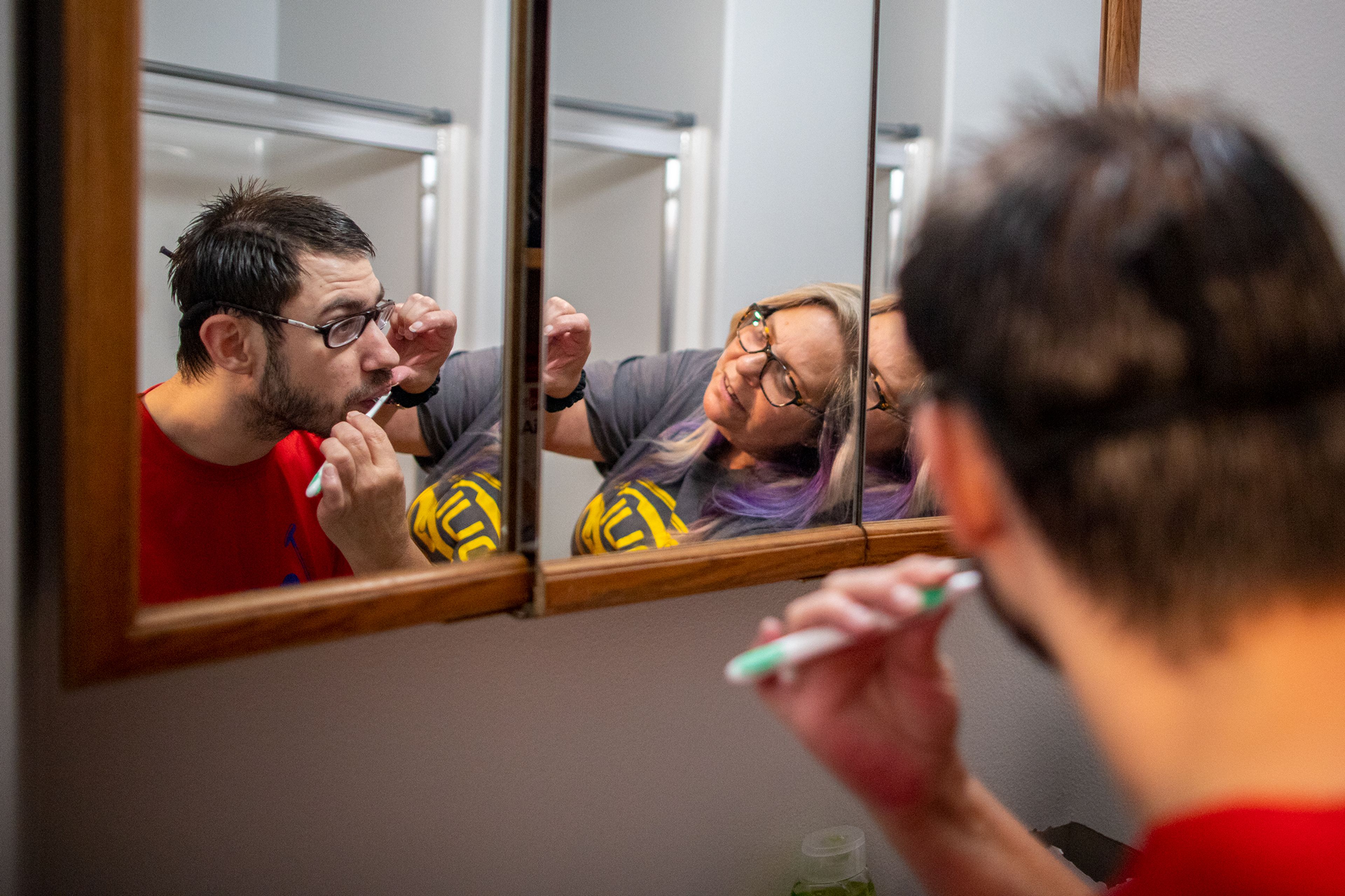 Kees Beehner, left, receives some assistance brushing his teeth from 24-Hour House Lead Jill Grant in Beehner’s bathroom at his supported living resident in Lewiston on the morning of Sept. 21. Beehner’s, who has relied on supported living services most of his life, has lived with 24-hour residential habilitation support from Opportunities Unlimited Inc. since 2019.