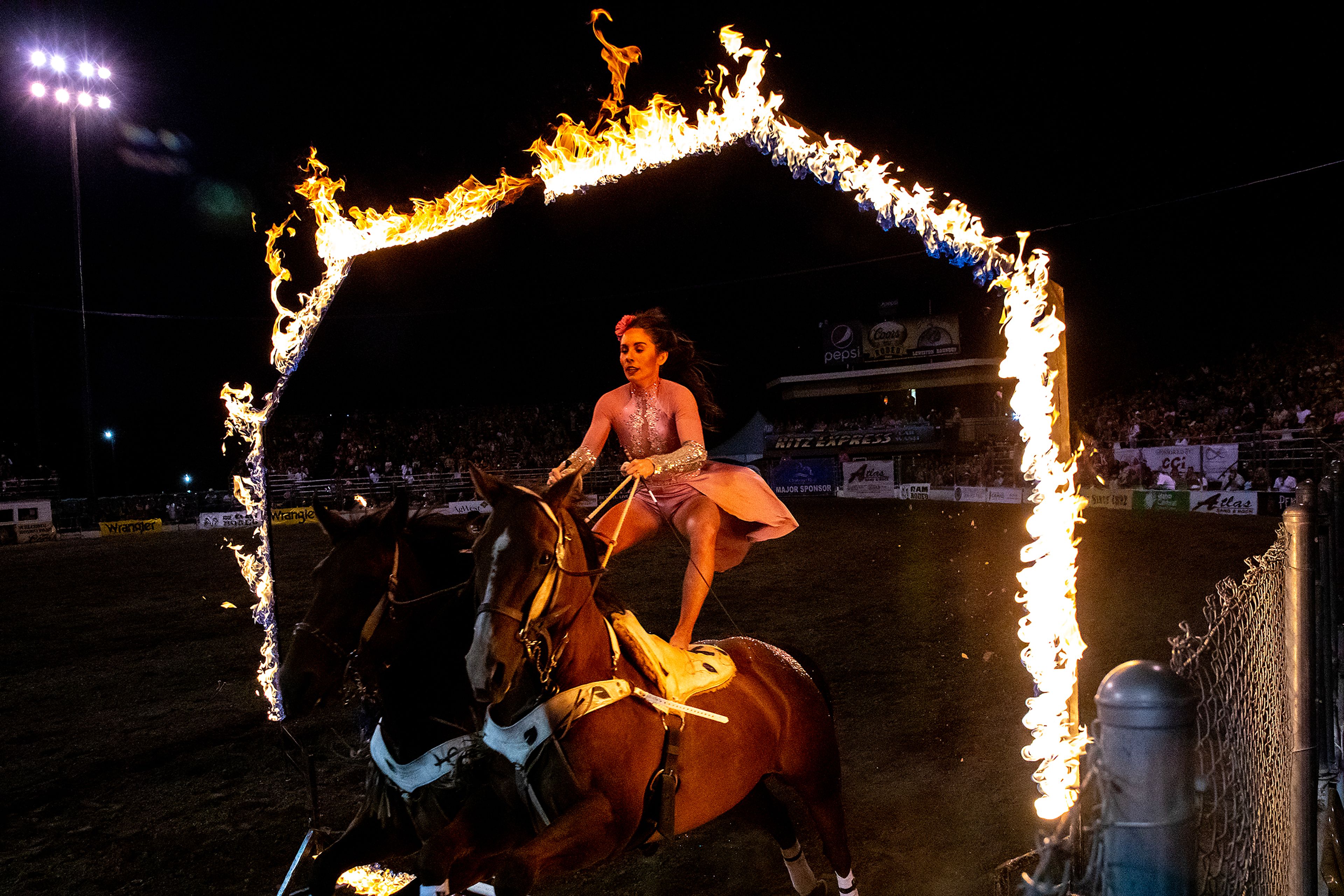 Haley Proctor jumps her horses through a ring of fire on night 3 Friday at the Lewiston Roundup.