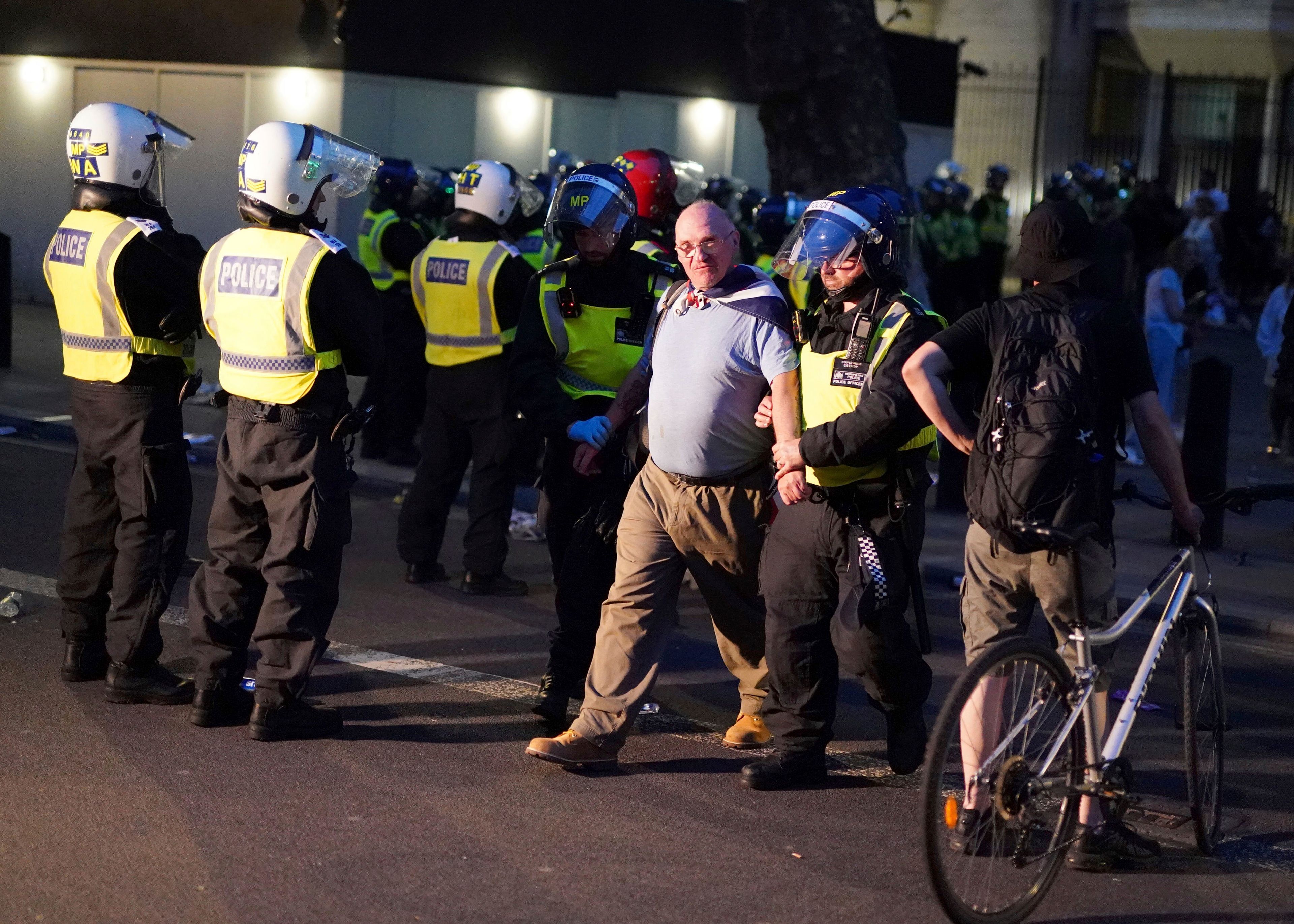 A man is detained as people attend the 'Enough is Enough' protest in Whitehall, London, Wednesday July 31, 2024, following the fatal stabbing of three children at a Taylor Swift-themed holiday club on Monday in Southport. (Jordan Pettitt/PA via AP)