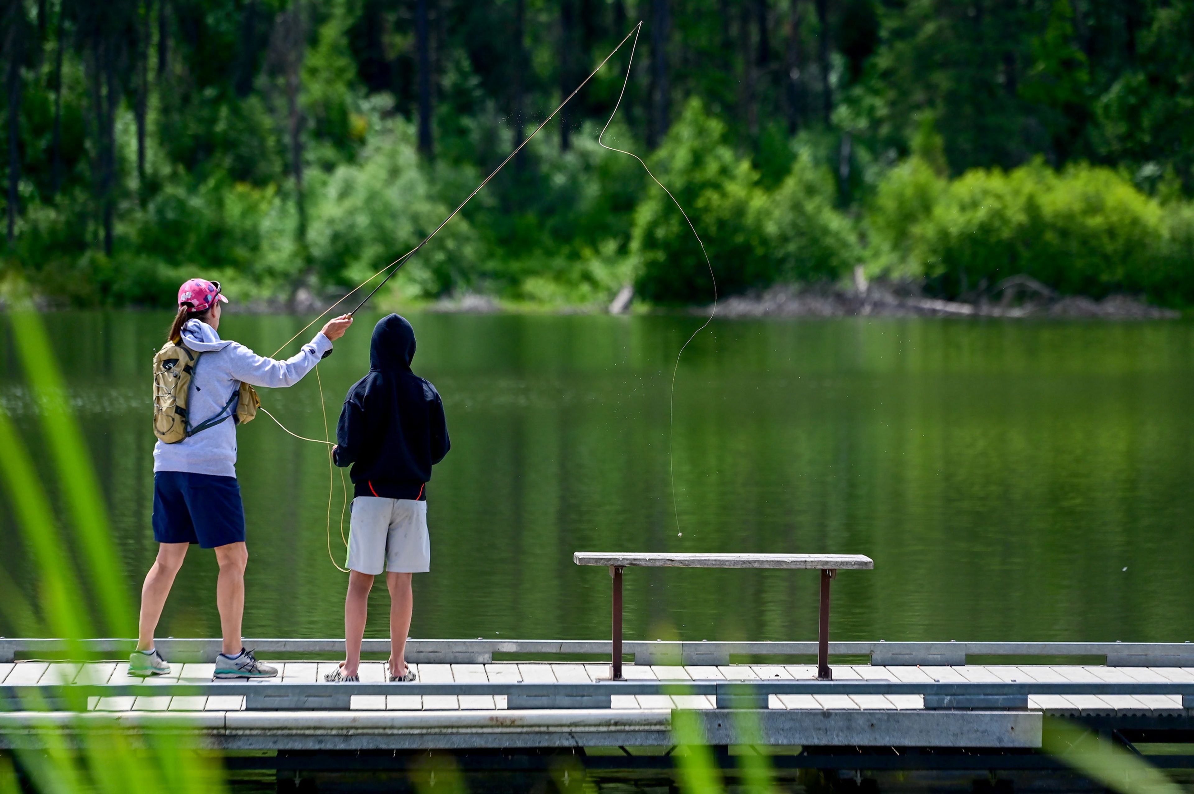 Robin Barnes, of Moscow, teaches nephew Dominik Burton, 12, of Chicago, how to fly fish at the Spring Valley Reservoir outside of Troy on Friday.