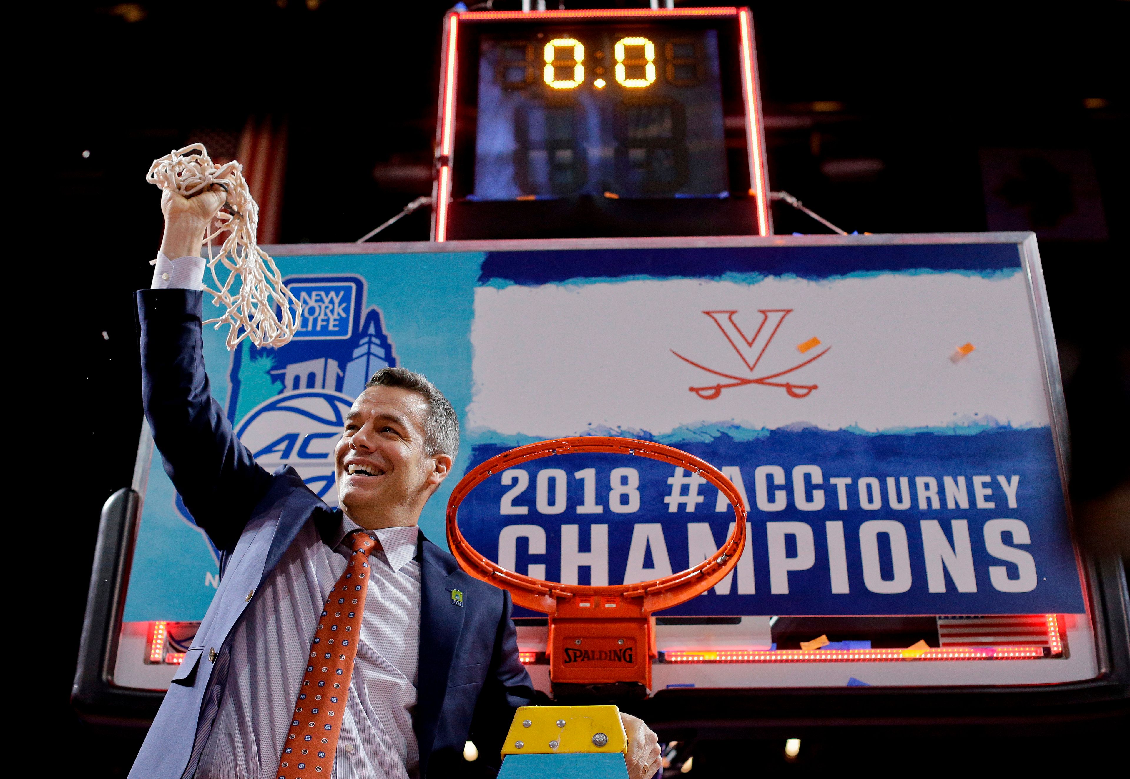 Virginia head coach Tony 
Bennett holds up the net after defeating North Carolina in the championship game of the Atlantic Coast Conference Tournament on March 10, 2018 in New York.
