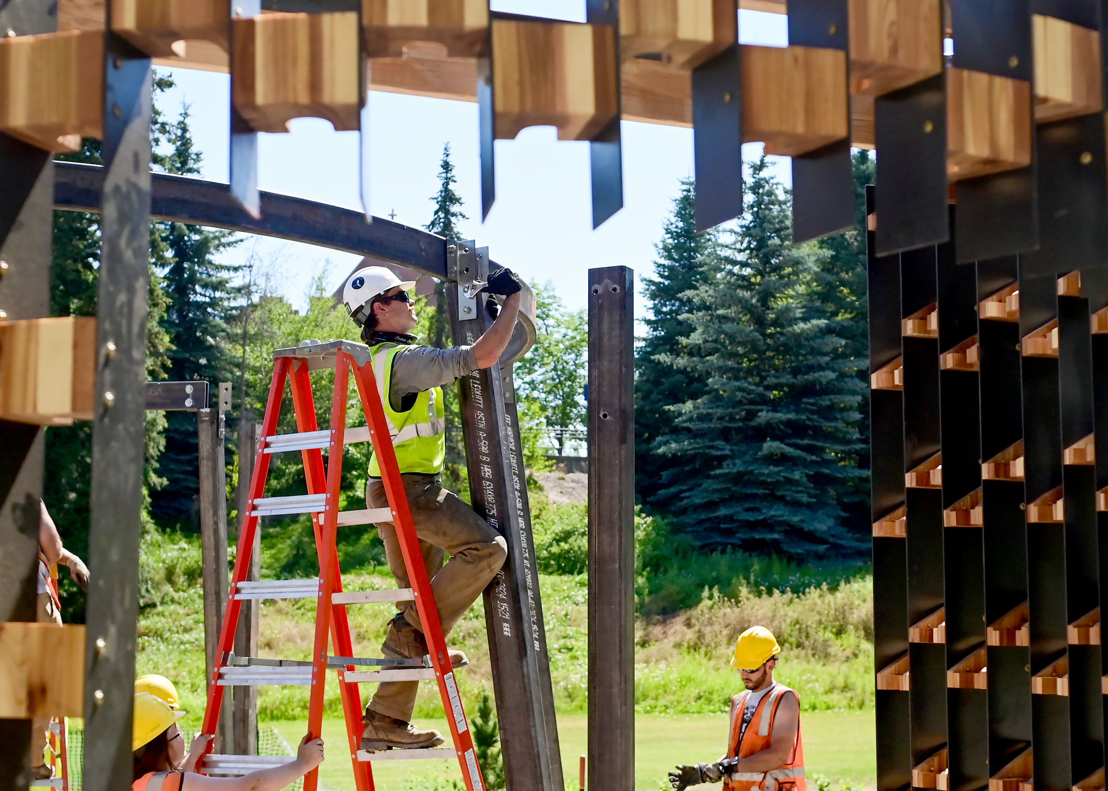 Korbyn Averett, a University of Idaho graduate architecture student, tightens bolts on the memorial structure of the Vandal Healing Garden and Memorial in Moscow on Tuesday.