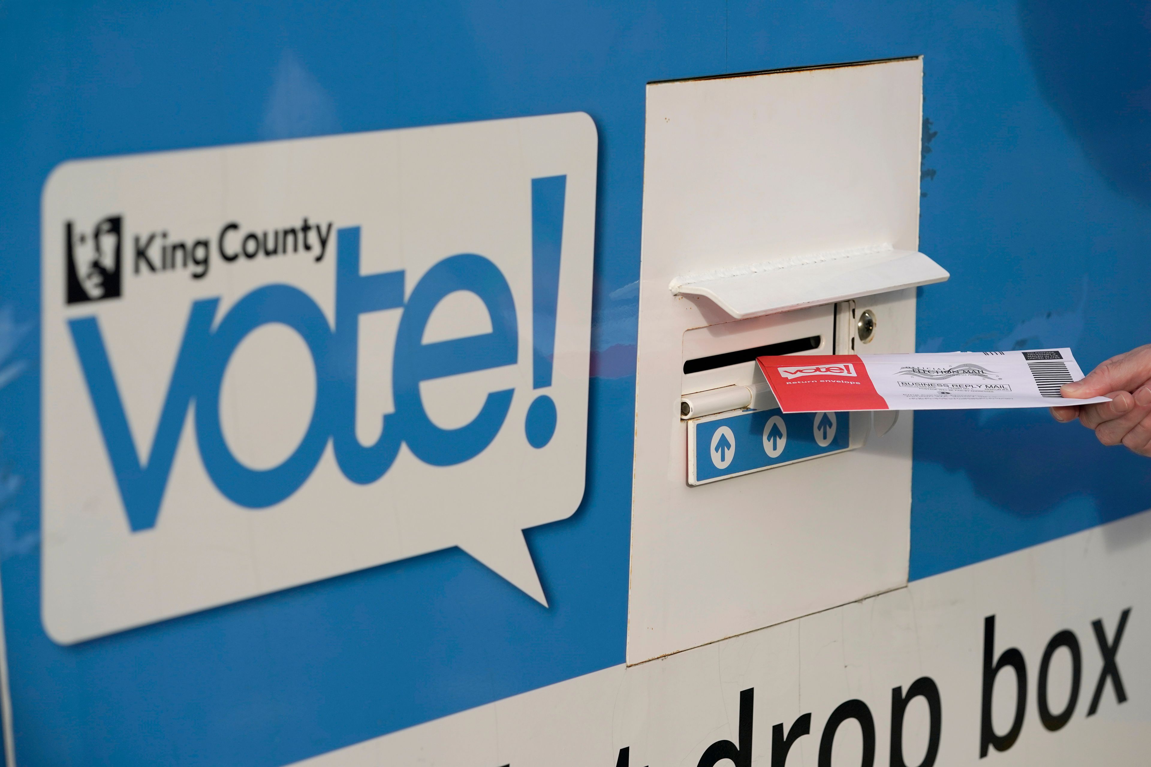 FILE - A person puts their ballot in a drop box on Oct. 27, 2020, at a library in Seattle. A Washington state judge on Friday, June 7, 2024, turned back an attempt by GOP backers of three initiatives to keep the fiscal impact of the measures off the November ballot.