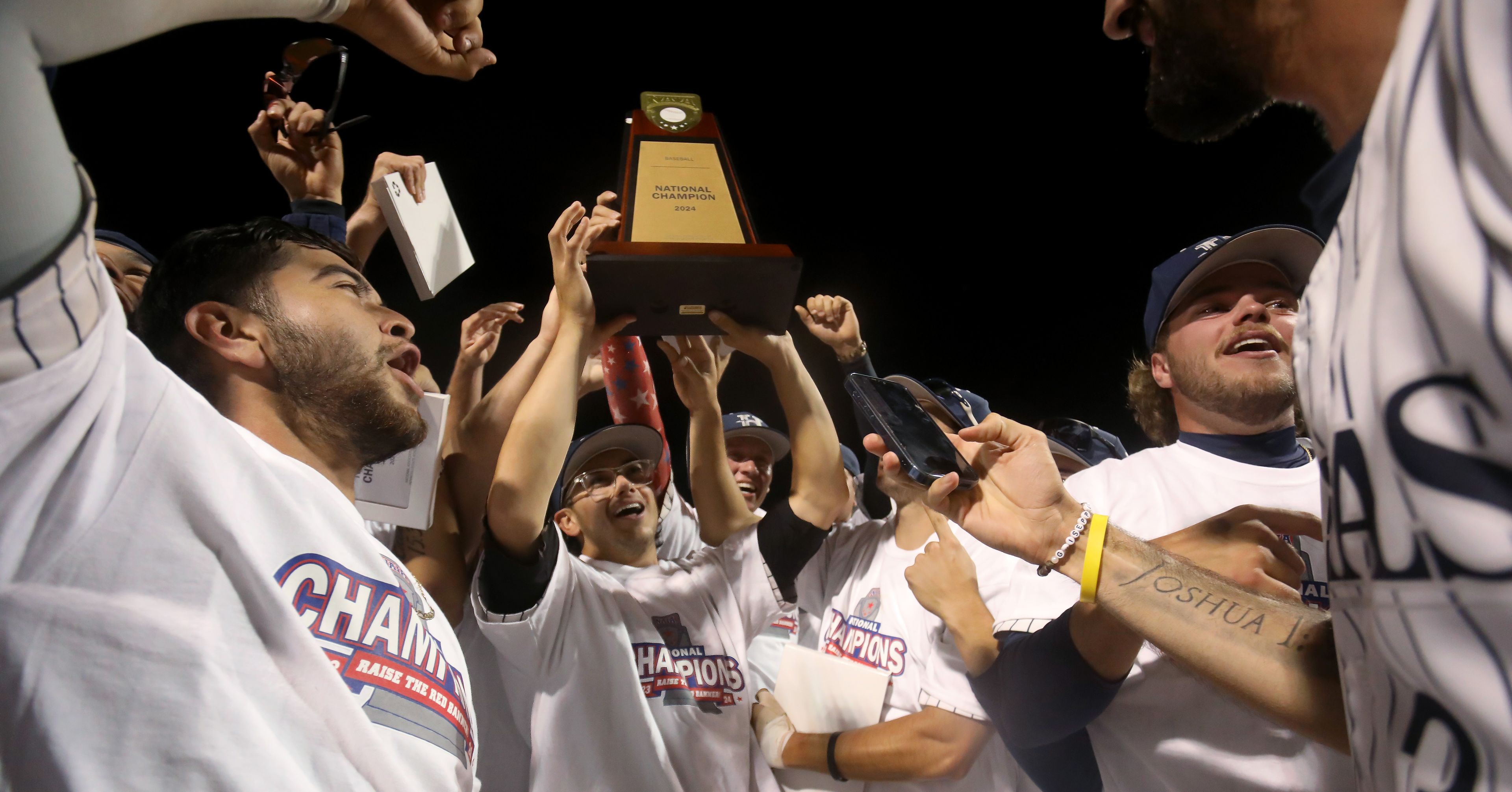 Hope International raises the national champion trophy after beating Tennessee Wesleyan in the championship game of the NAIA World Series at Harris Field in Lewiston on Friday.