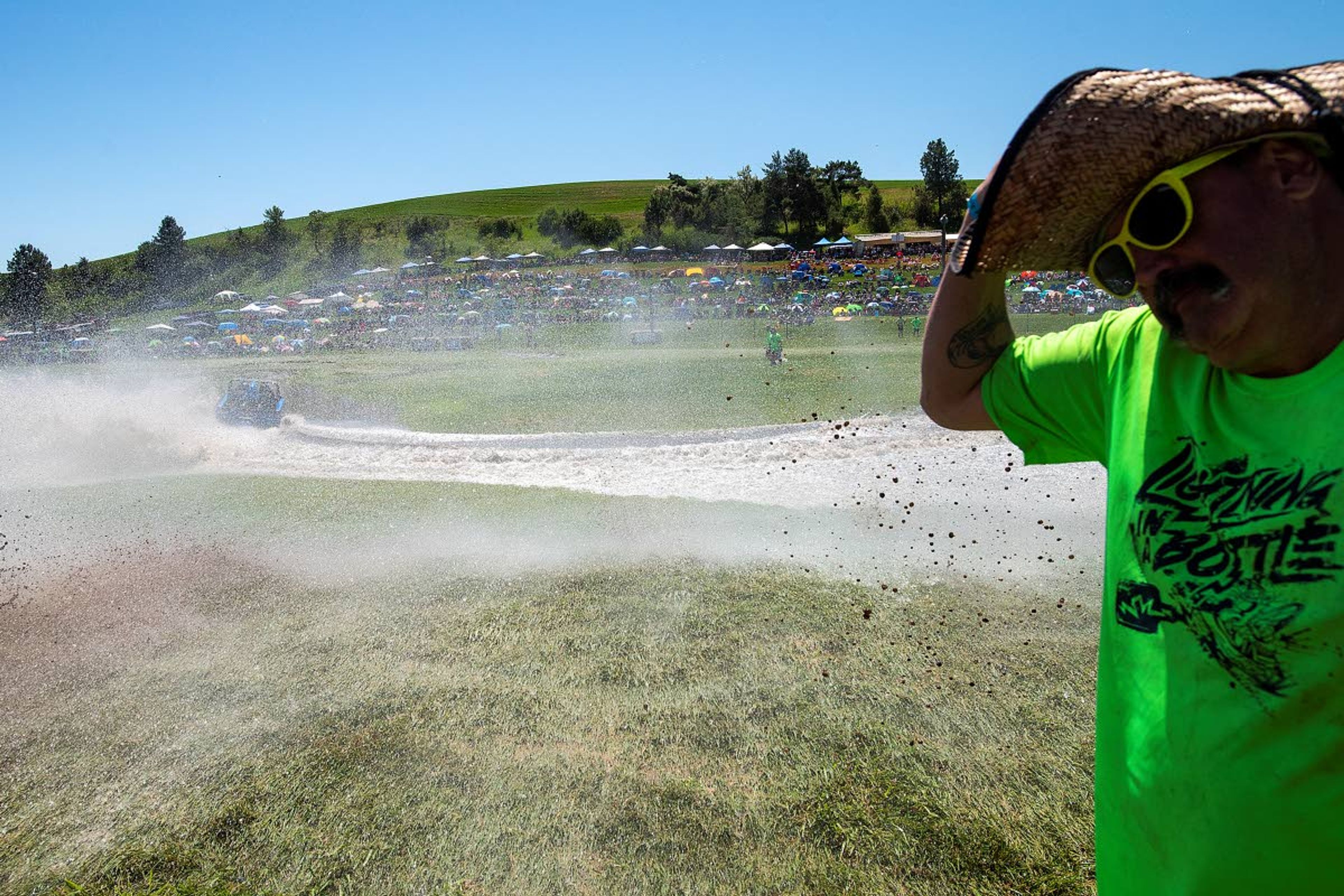 Webb’s Slough crew member James Brown, of Spokane, turns his back as water sprays into the air after a sprint boat makes its turn around the first corner of the Webb’s Slough races on Saturday in St. John.