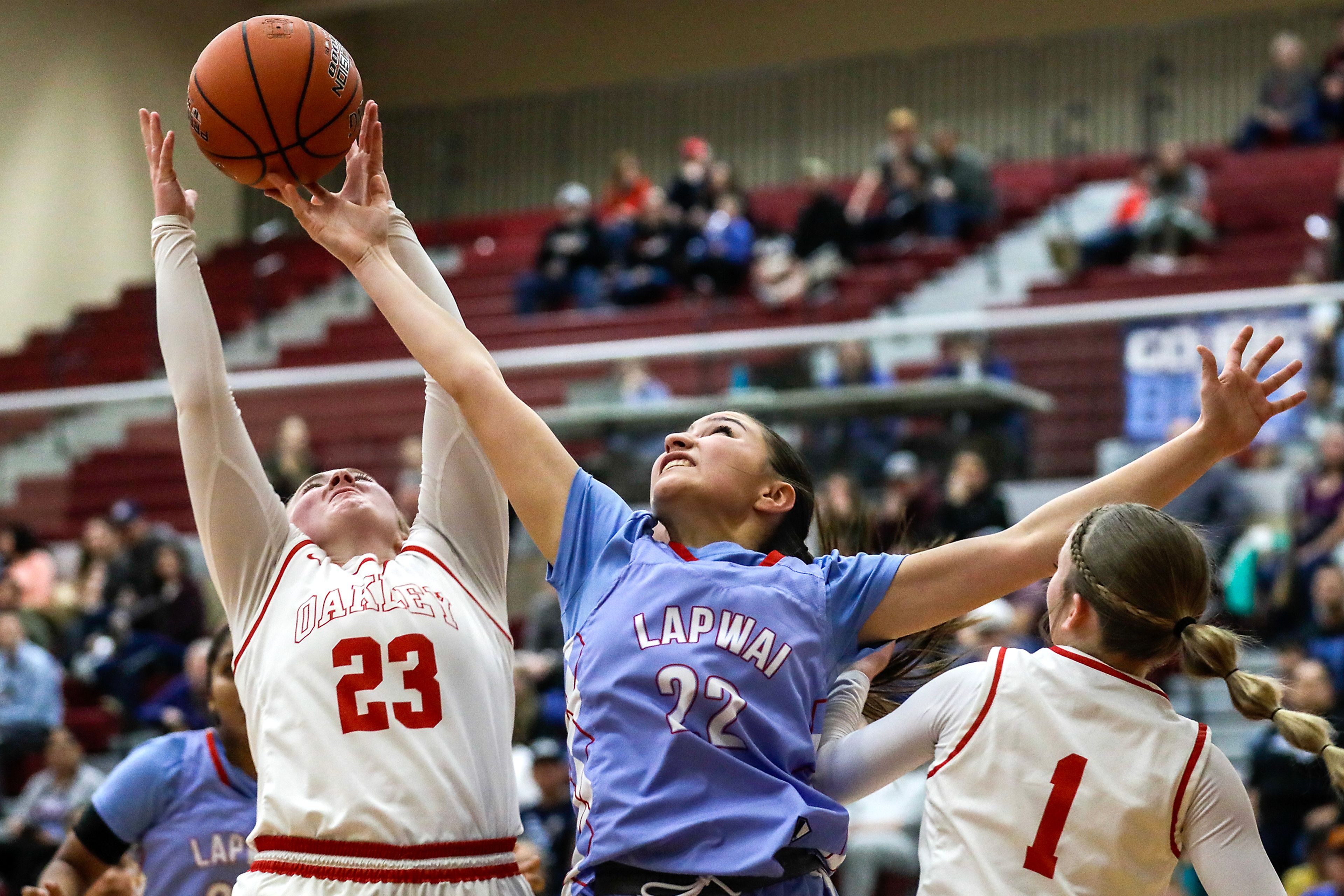 Lapwai's Taya Yearout, center, competes for a rebound with Oakley guard Kaymbri Beck, left, during an Idaho Class 1A DI girls state semifinal game Friday at Columbia High School.