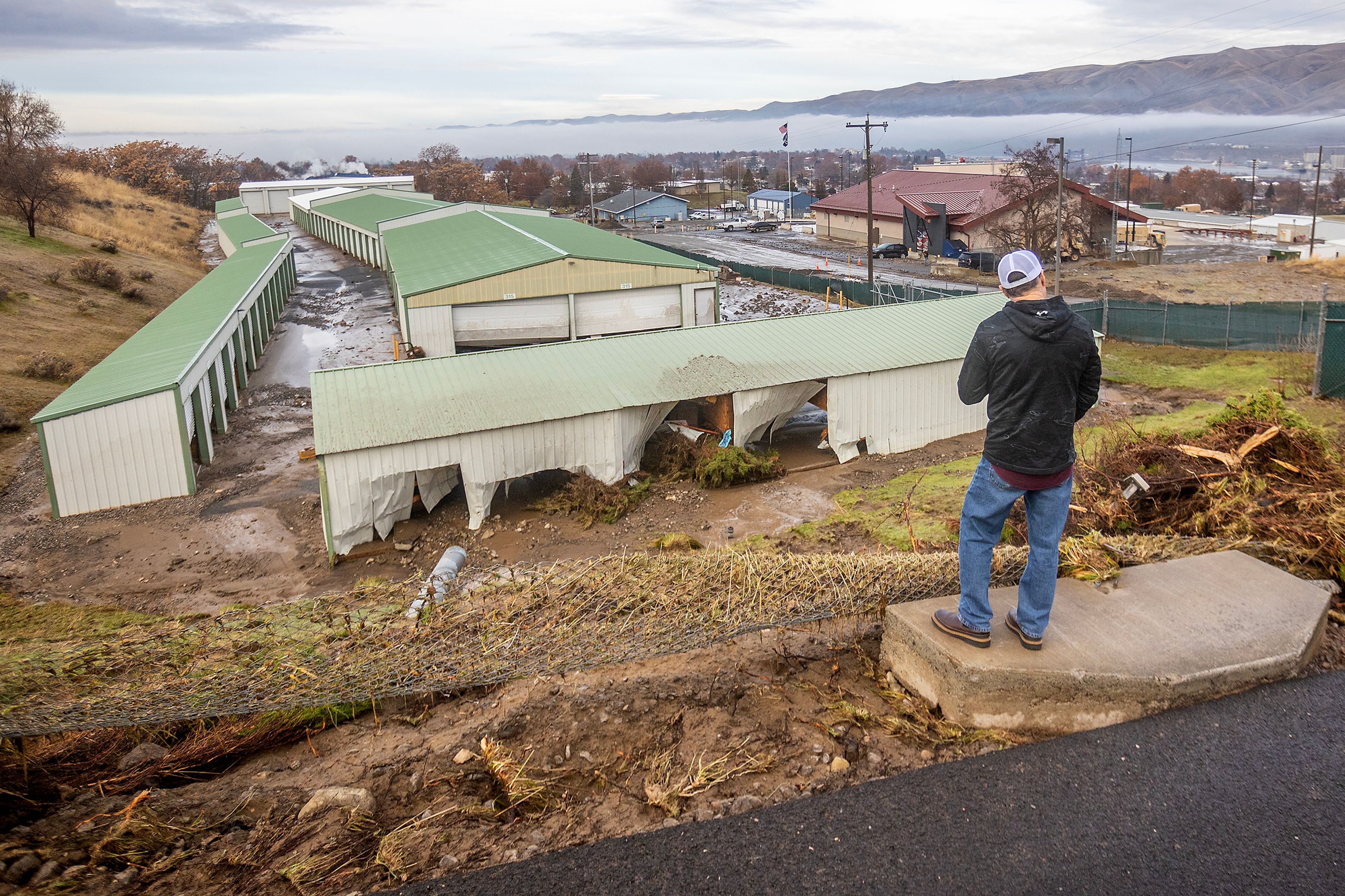 A man looks over the damage to 16th Avenue Mini Storage after a water reservoir at the corner of 16th Avenue and 29th Street burst in the early hours of Wednesday morning in Lewiston.