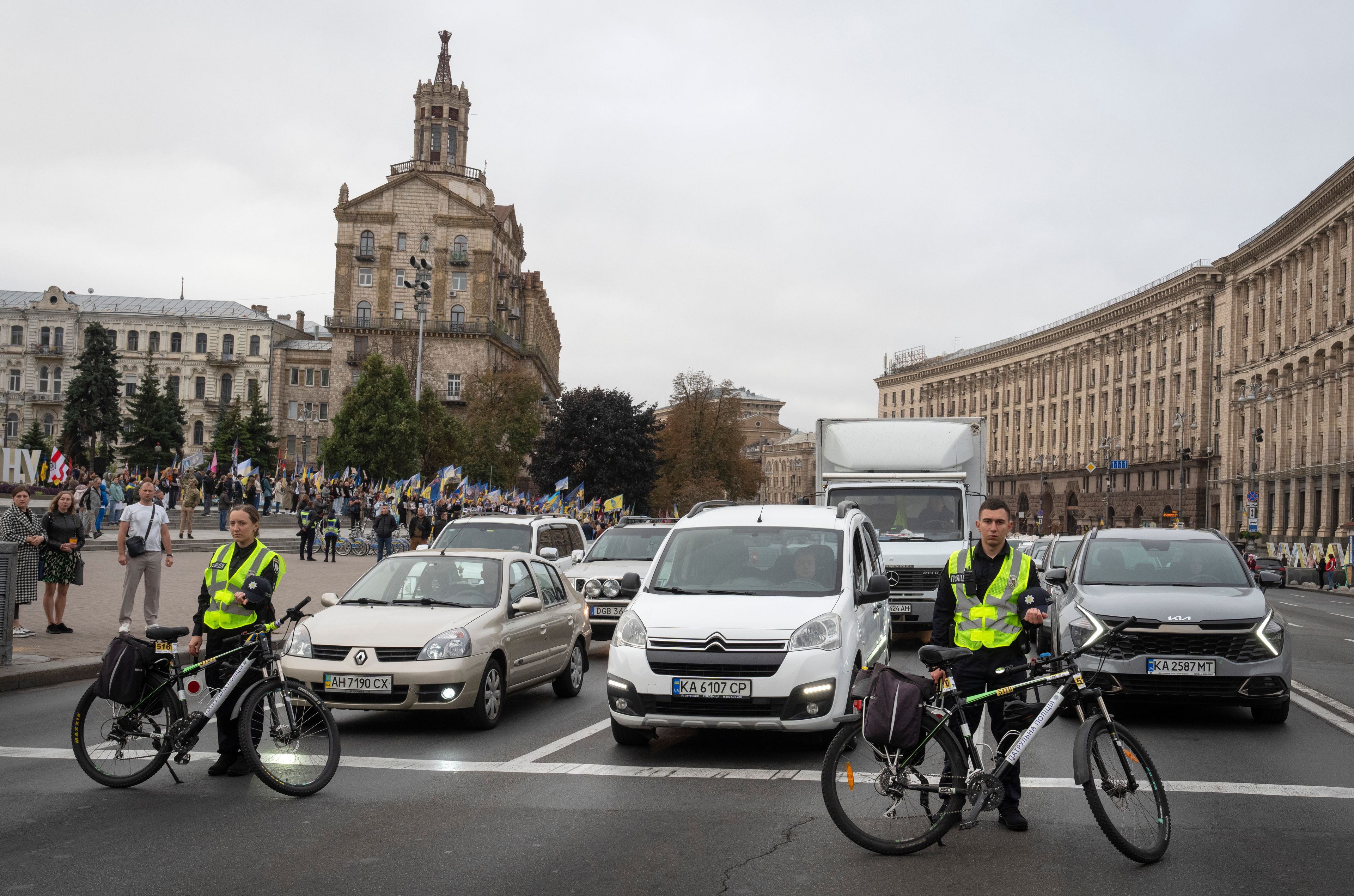 Drivers stop their cars and passerby bow their heads to keep a nationwide minute of silence in memory of fallen soldiers, who defended their homeland in war with Russia, on Defenders Day in Independence square in Kyiv, Ukraine, Tuesday, Oct. 1, 2024. (AP Photo/Efrem Lukatsky)