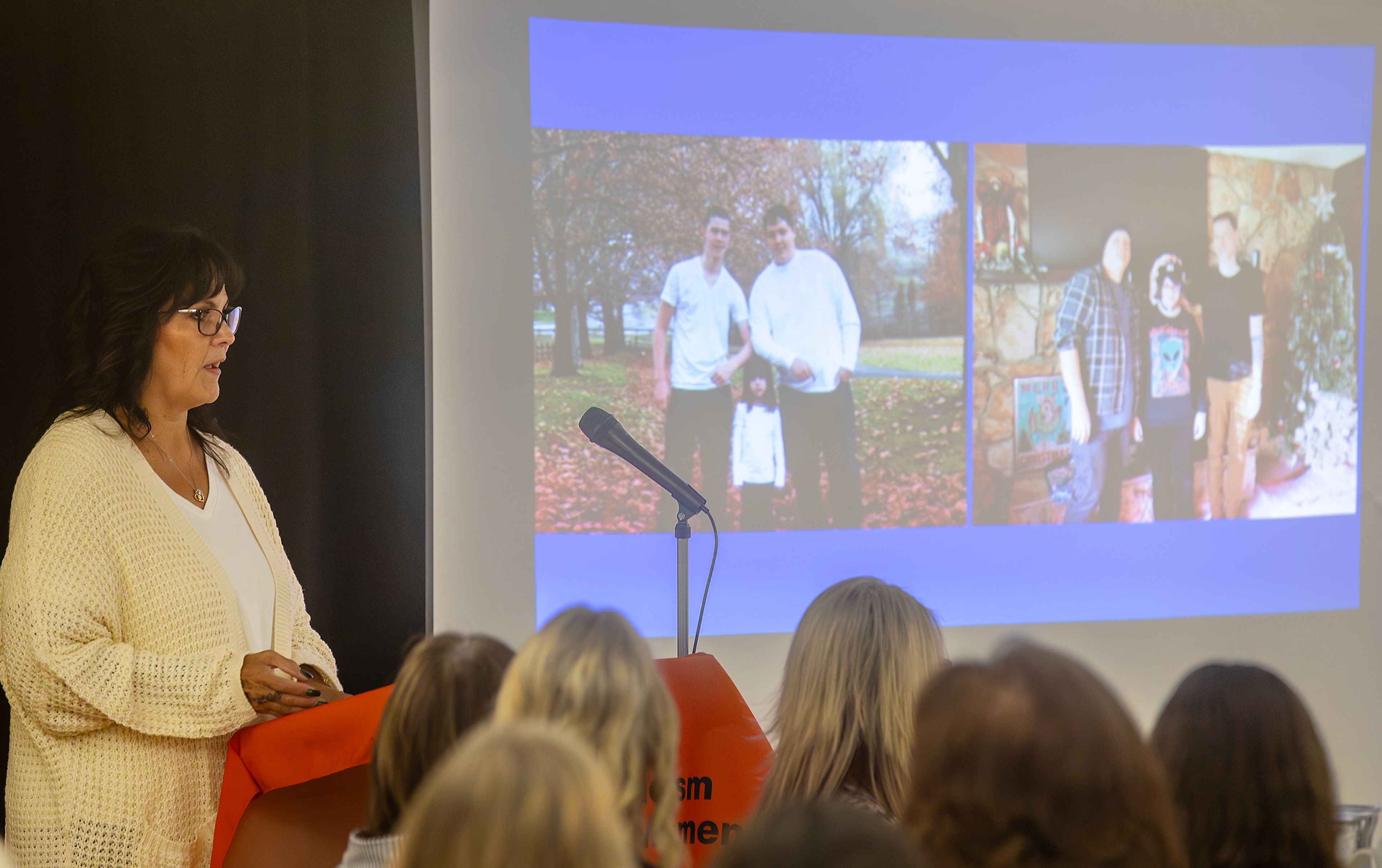 Zenita Delva, executive director of the 2nd Judicial District CASA program, speaks Friday as a photo of her family appears on the screen next to her at the Inspiring Women Brunch at the YWCA in Lewiston.