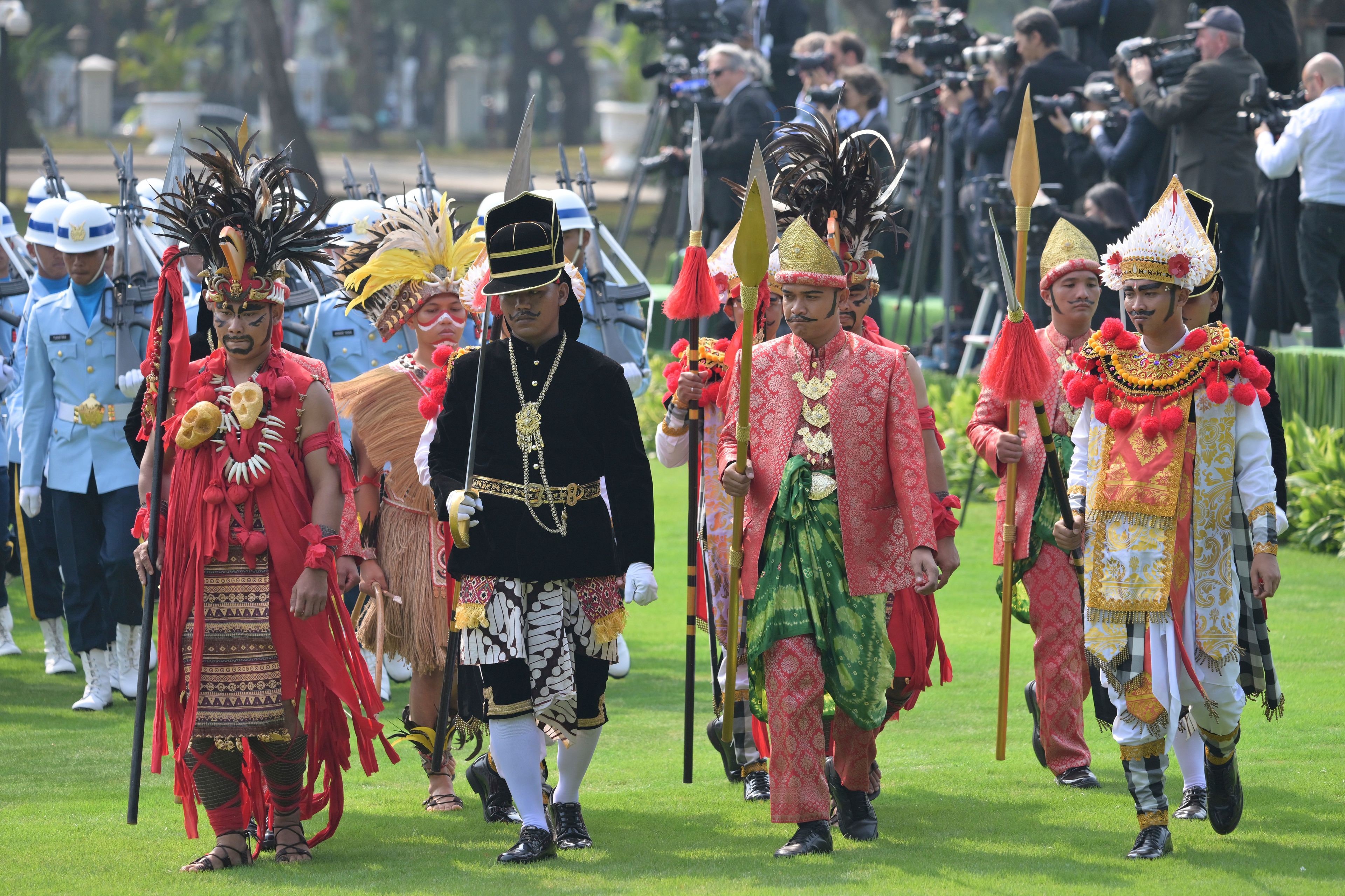 Participants in traditional attire and uniformed personnel stand in formation ahead of the ceremonial welcome for Pope Francis at the Presidential Palace in Jakarta Wednesday, Sept. 4, 2024.