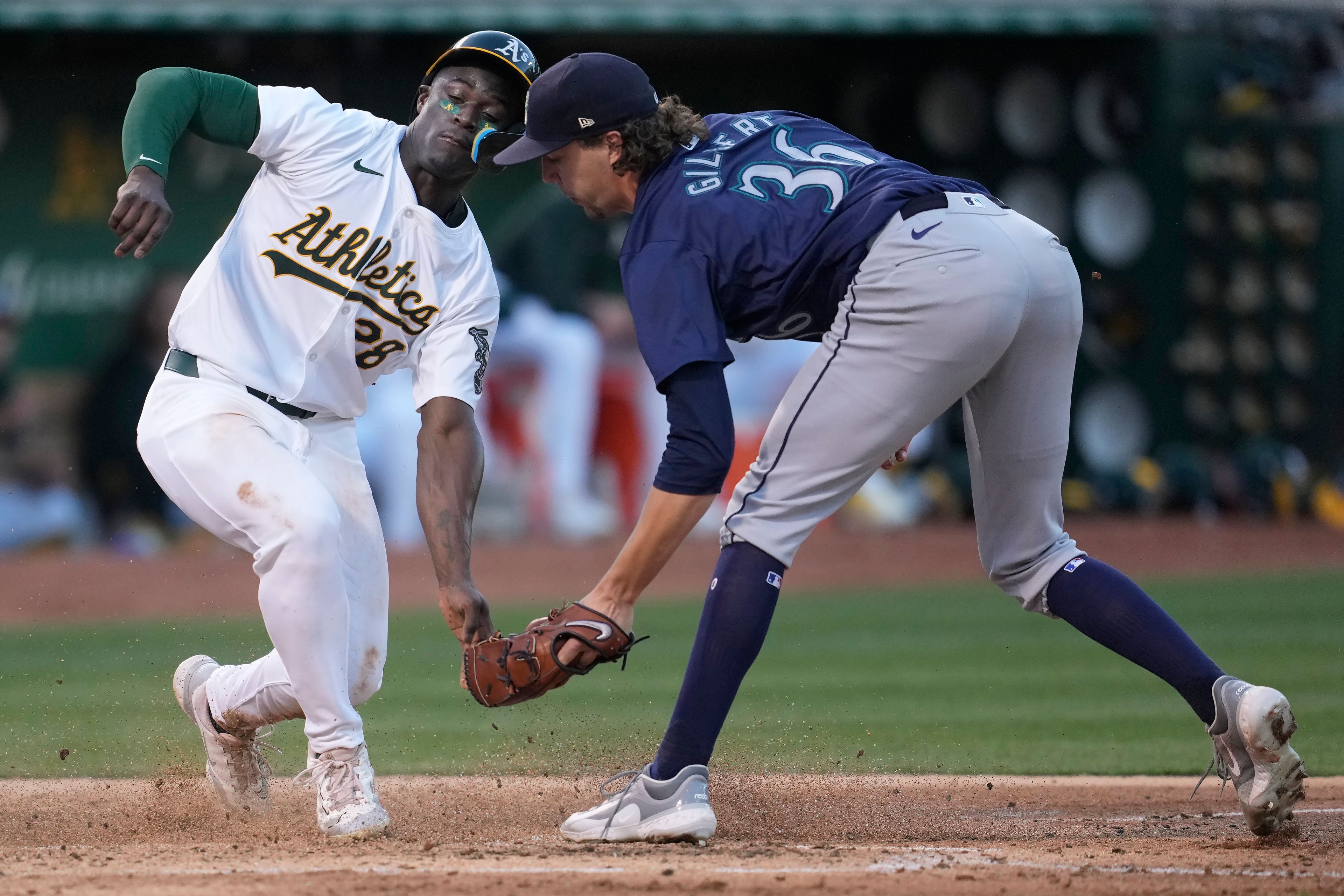 Oakland Athletics' Daz Cameron, left, scores against Seattle Mariners pitcher Logan Gilbert (36) during the fifth inning of a baseball game in Oakland, Calif., Wednesday, June 5, 2024. (AP Photo/Jeff Chiu)