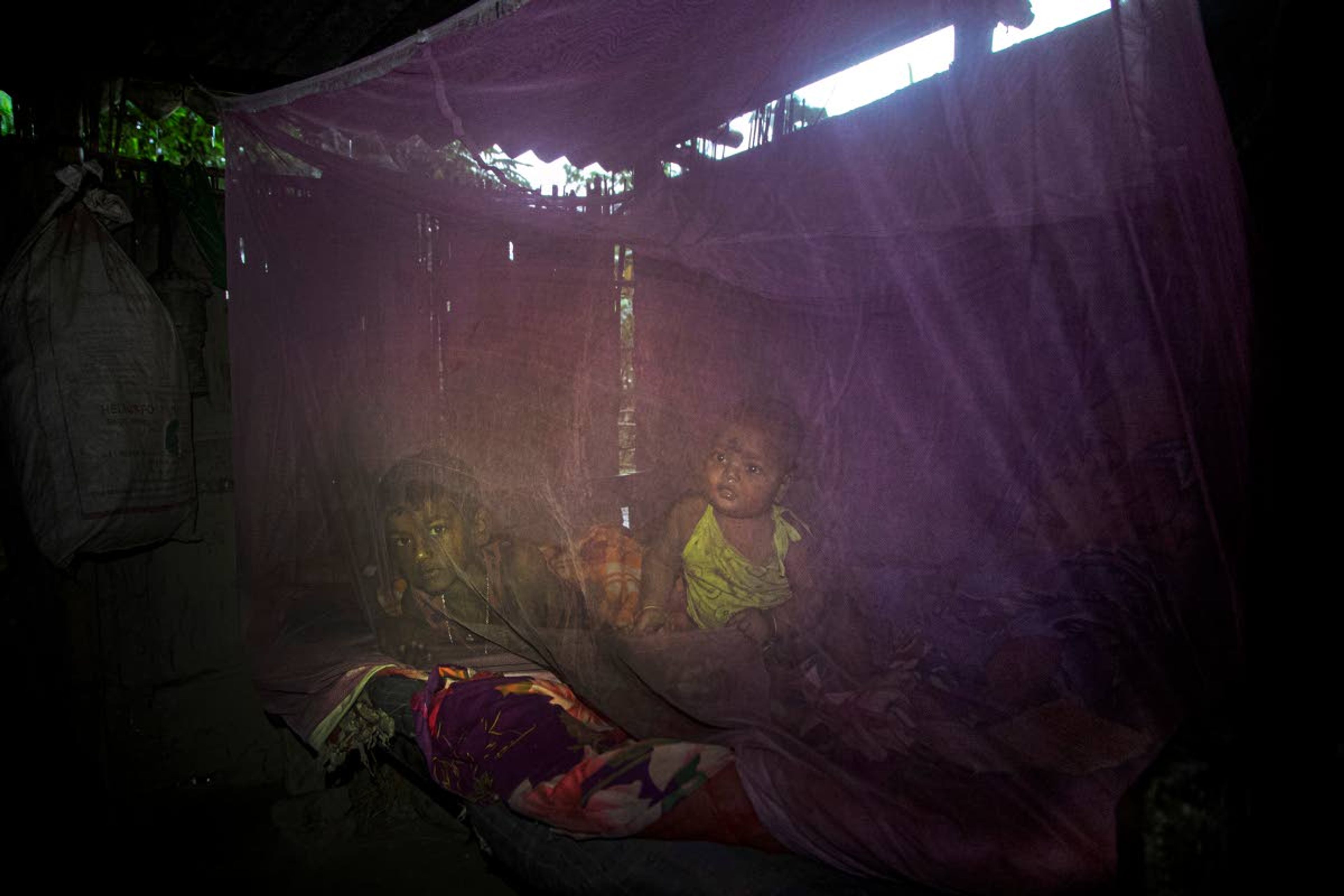 Ramananda Sarkar's children rest inside a mosquito net at home in Theng Bhanga village, in Morigaon district, India, Tuesday, Sept. 22, 2020. Sarkar, who was deep in debt and desperate for money, took the job of lighting funeral pyres after failing to pay back a loan he'd taken to start selling sugarcane juice on a wooden cart. Dealing with corpses is a stigma that's only been made worse by the coronavirus, which has killed more than 100,000 people in India out of 6.4 million reported infections. “I don’t want my sons to become cremators like me," Sarkar said. "I want them to go to school and become good human beings and earn respect from the society, not like me who has to meet his family in the dark.” (AP Photo/Anupam Nath)