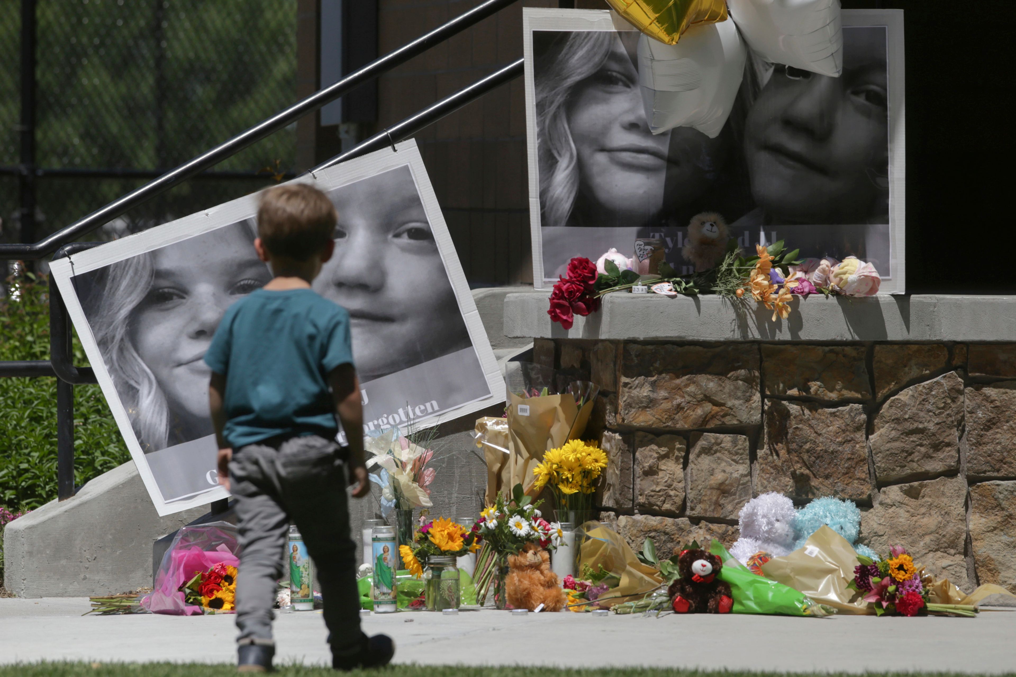 FILE - A boy looks at a memorial for Tylee Ryan and Joshua "JJ" Vallow in Rexburg, Idaho, on June 11, 2020. An Idaho jury has convicted Chad Daybell of murder in the 2019 deaths of his wife and his girlfriend’s two youngest children. The verdict Thursday, May 30, 2024, marks the end of a yearslong investigation that included bizarre claims of zombie children, apocalyptic prophesies and illicit affairs. (John Roark/The Idaho Post-Register via AP, File)