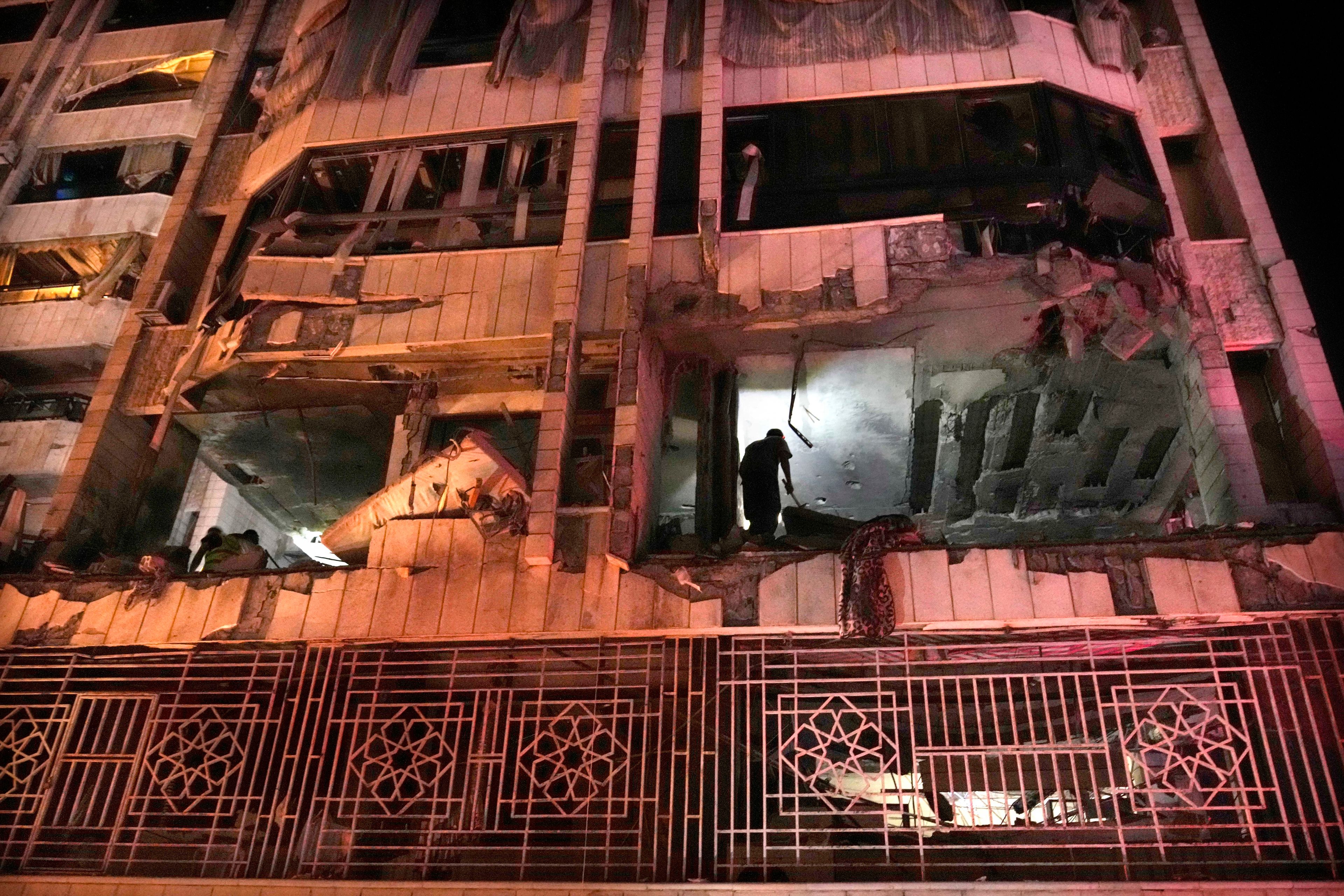 A rescue worker surveys an apartment hit by an airstrike in Beirut, Lebanon, early Thursday, Oct. 3, 2024. (AP Photo/Hussein Malla)