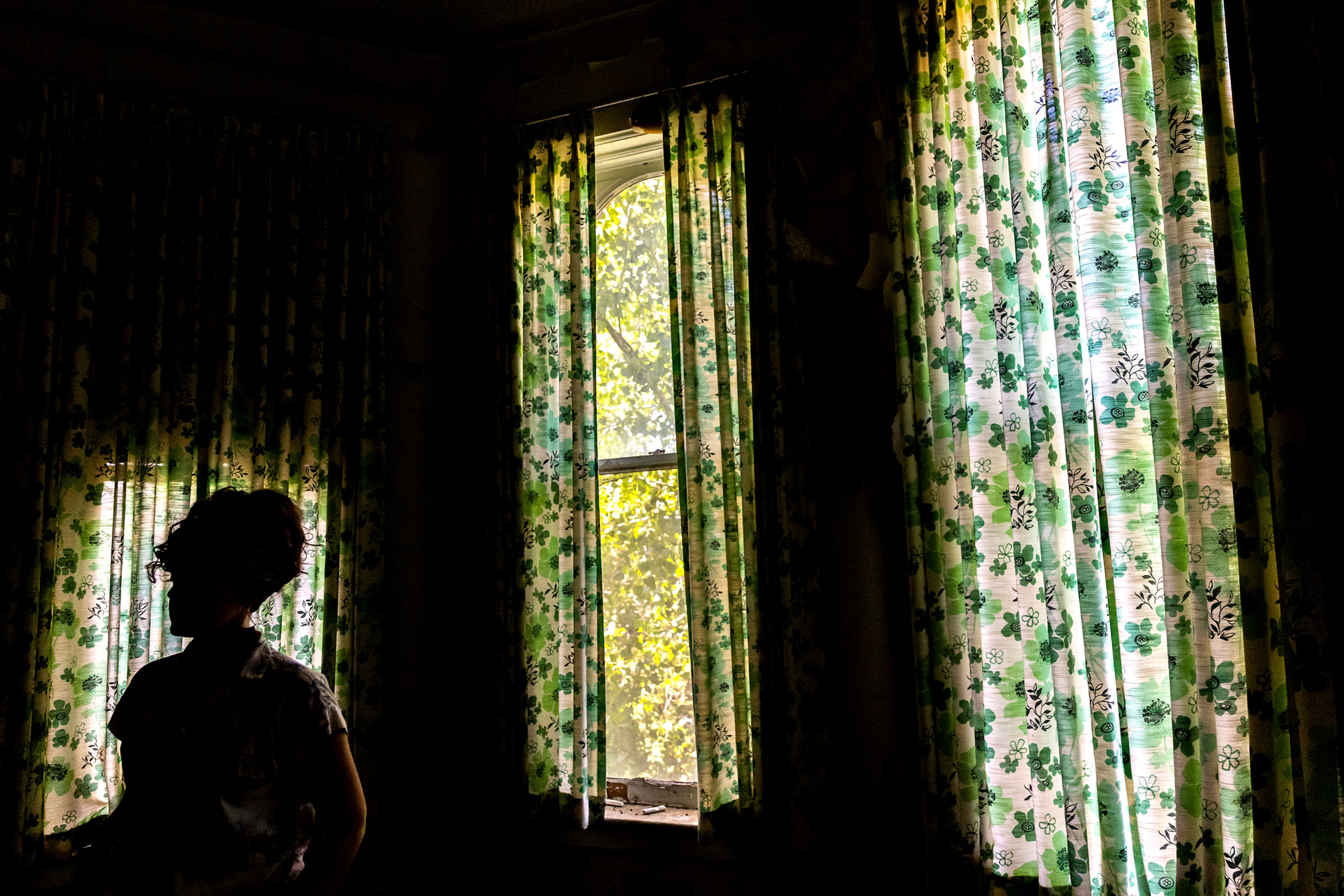 Laura Storm stand in front of curtains at St. Ignatius Hospital in Colfax.