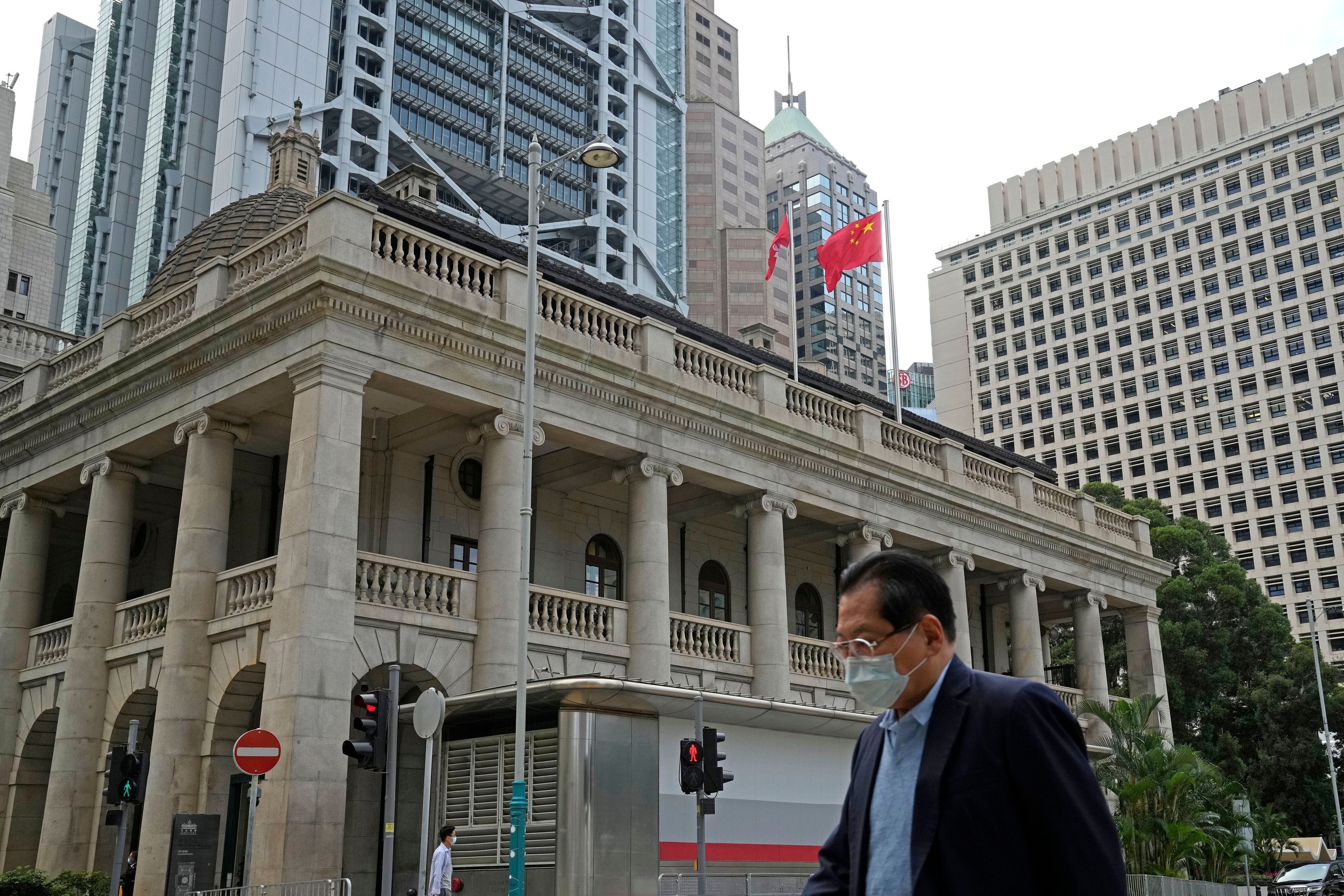 FILE - A pedestrian passes the Court of Final Appeal in Hong Kong, on March 30, 2022. A British judge who resigned from Hong Kong's top court last week said he stepped down because the rule of law in the city is in "grave danger” and judges operate in an “impossible political environment created by China.”