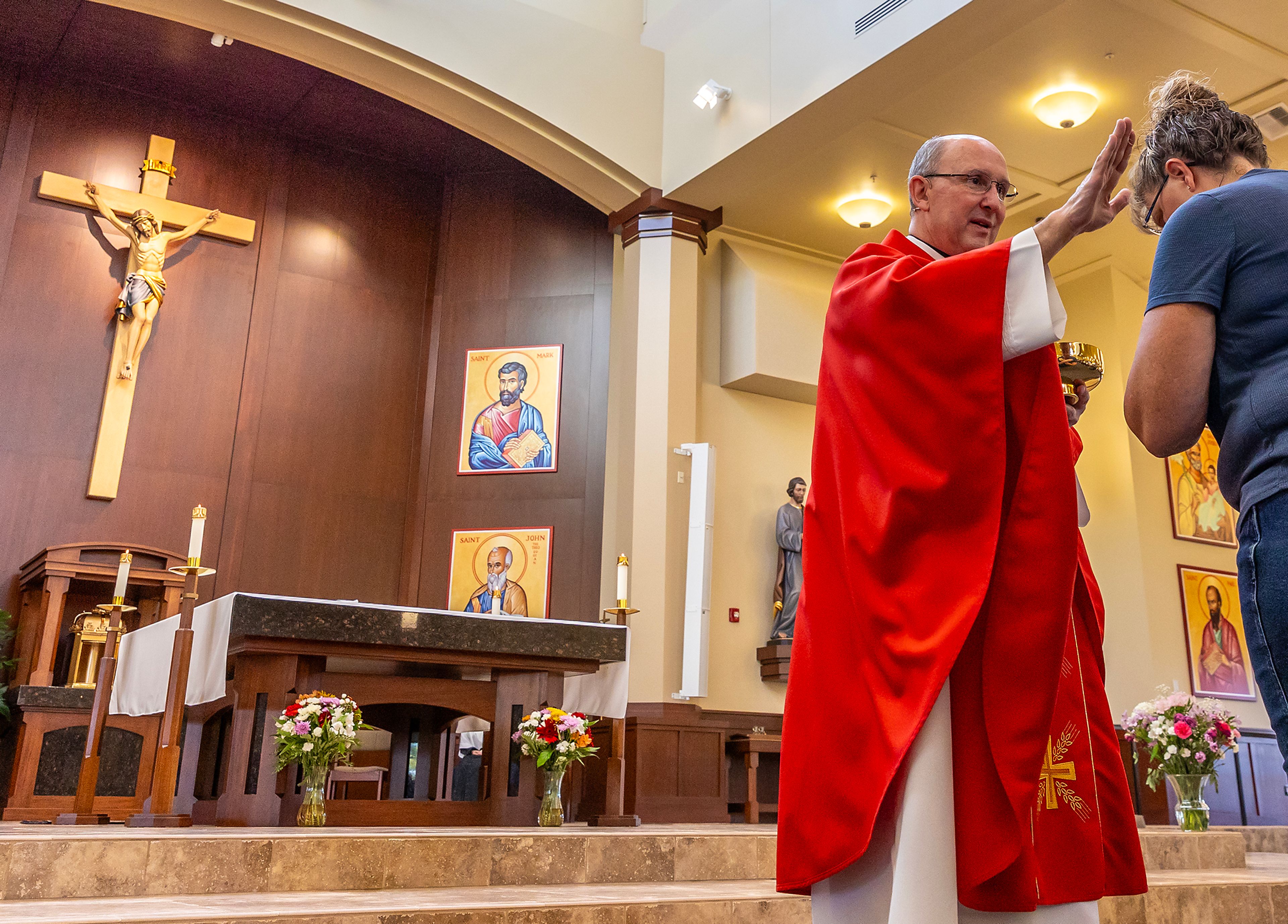 The Rev. Mike St. Marie gives a blessing while distributing holy communion Wednesday at All Saints Catholic Church in the Lewiston Orchards.