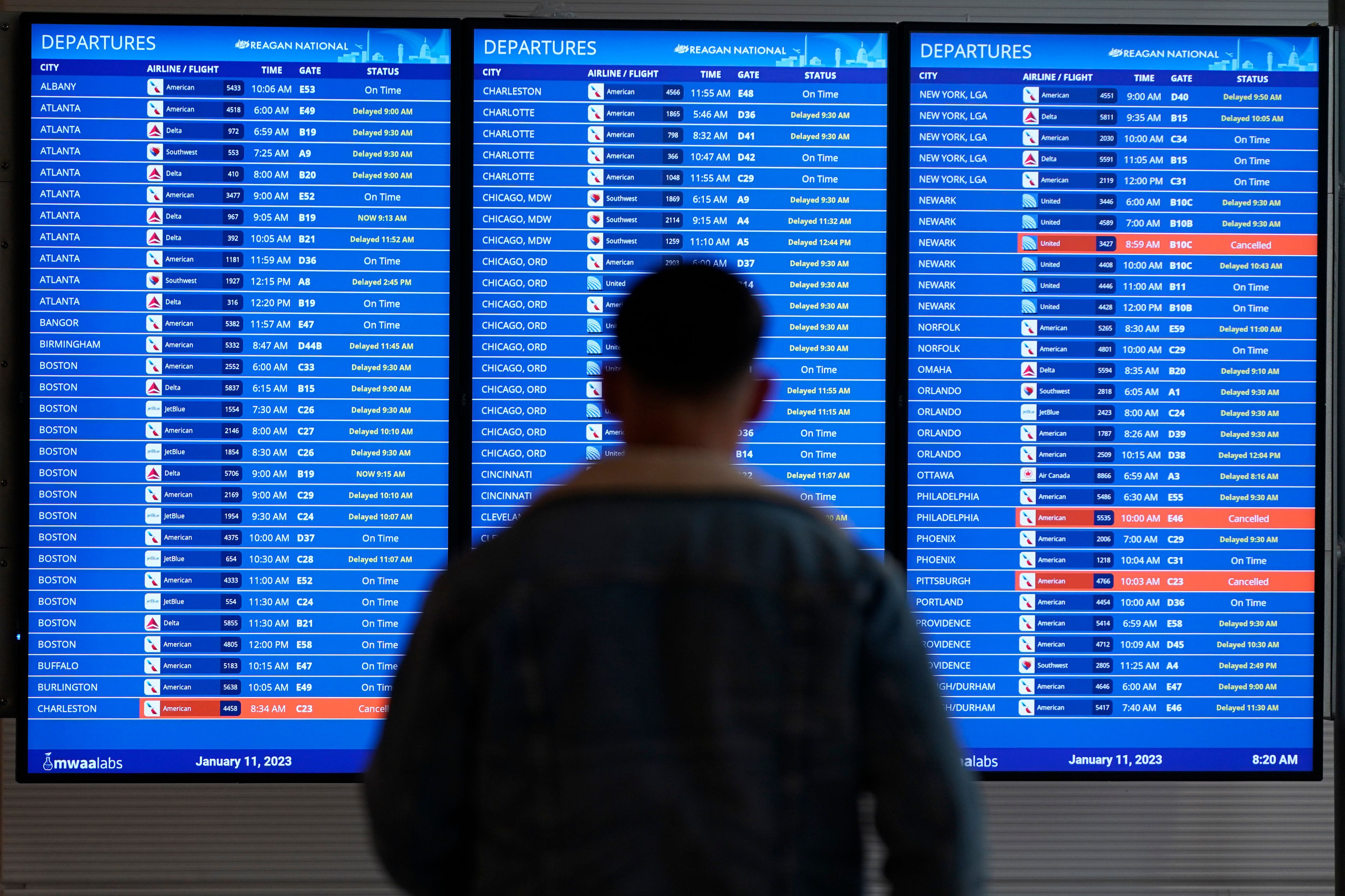 A traveler looks at a flight board with delays and cancellations at Ronald Reagan Washington National Airport in Arlington, Va., Wednesday.