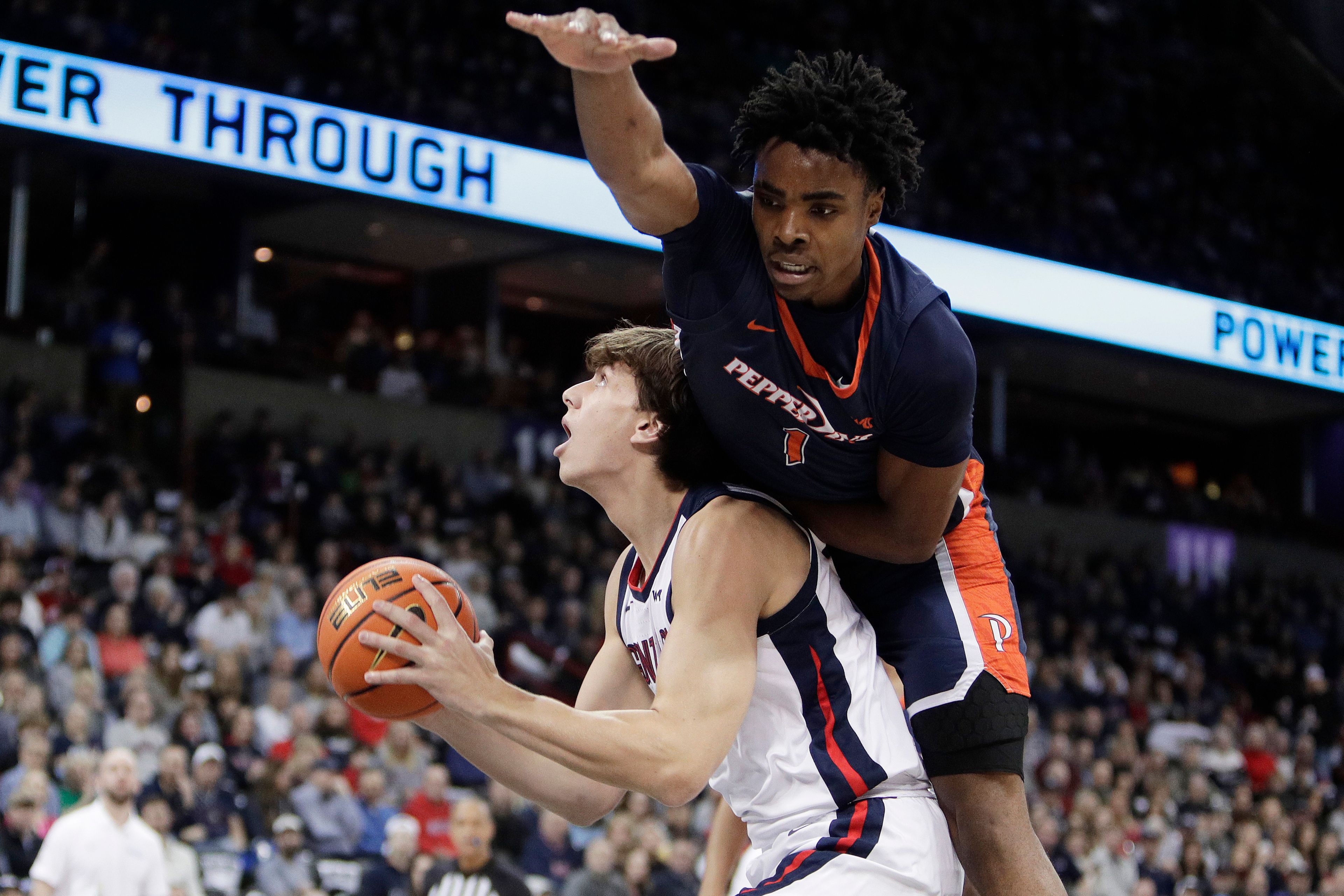 Gonzaga forward Braden Huff, left, drives to the basket while pressured by Pepperdine guard Michael Ajayi (1) during the a game Thursday in Spokane.