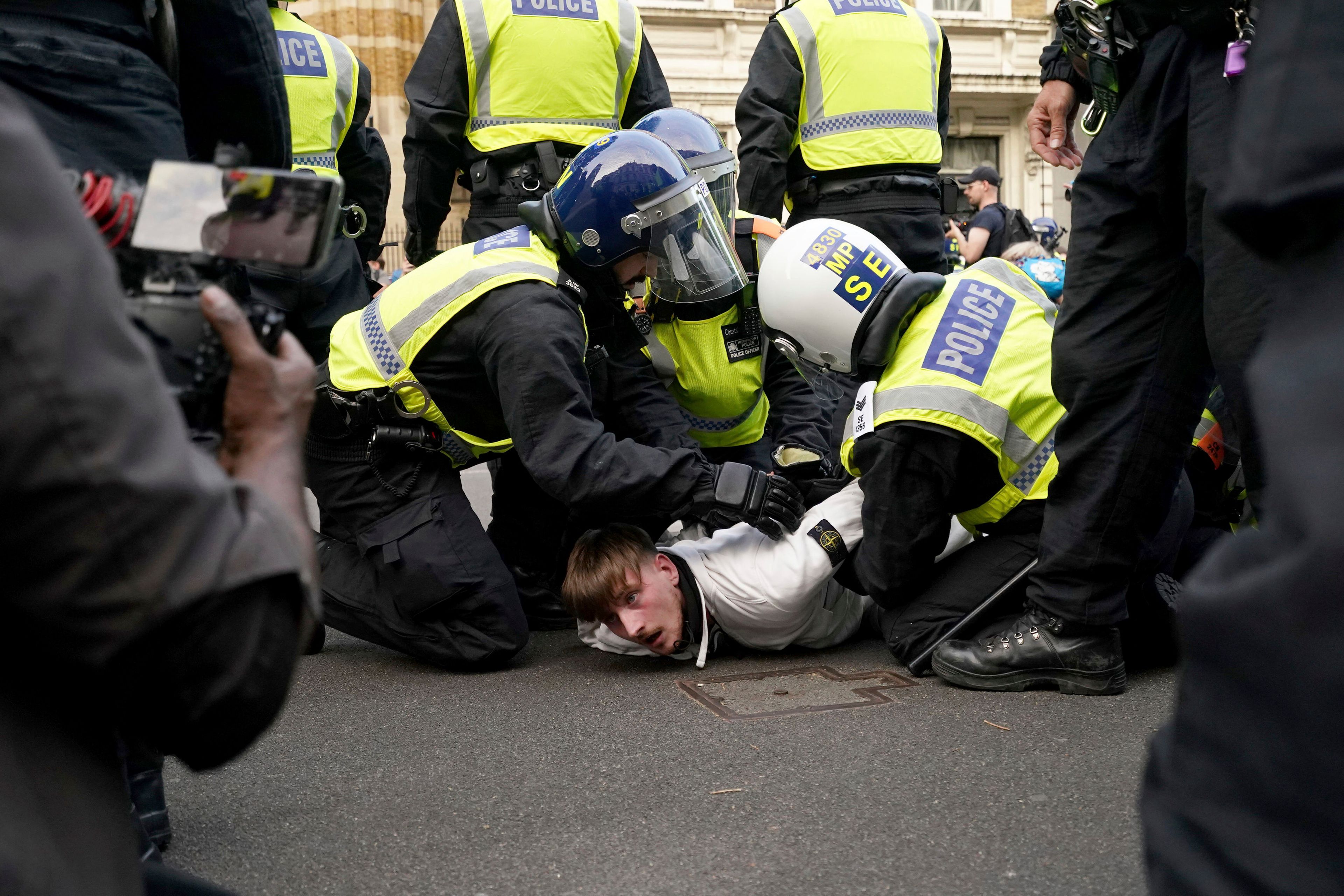 A protester is detained by police during the 'Enough is Enough' protest in Whitehall, London, Wednesday July 31, 2024, following the fatal stabbing of three children at a Taylor Swift-themed holiday club on Monday in Southport. (Jordan Pettitt/PA via AP)