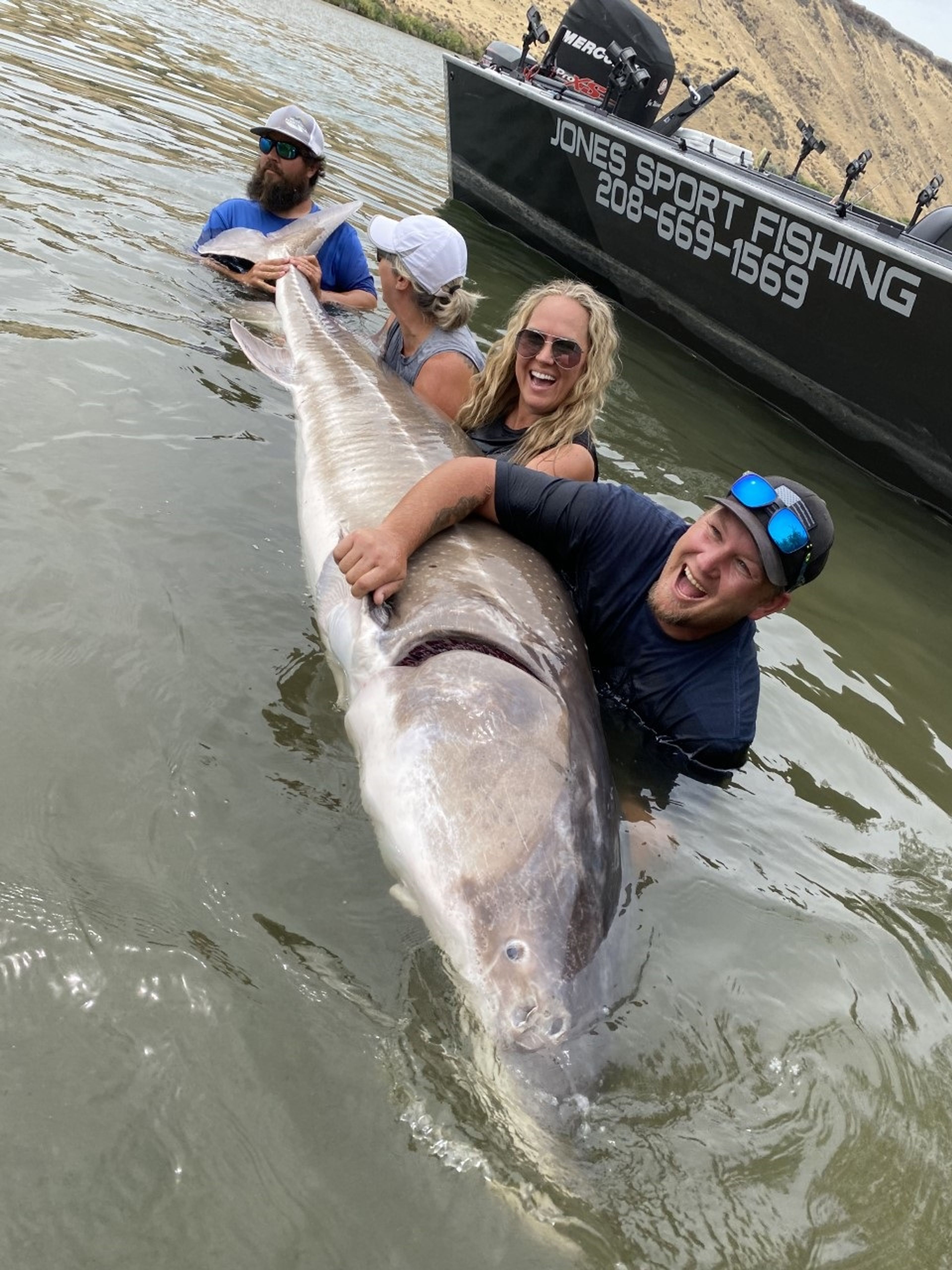 From left: Greg Poulsen, Wendy Guess and Angie Poulsen, all of Eagle Mountain, Utah, and fishing outfitter Brett Jones hold the new state record sturgeon, caught by Greg Poulsen.