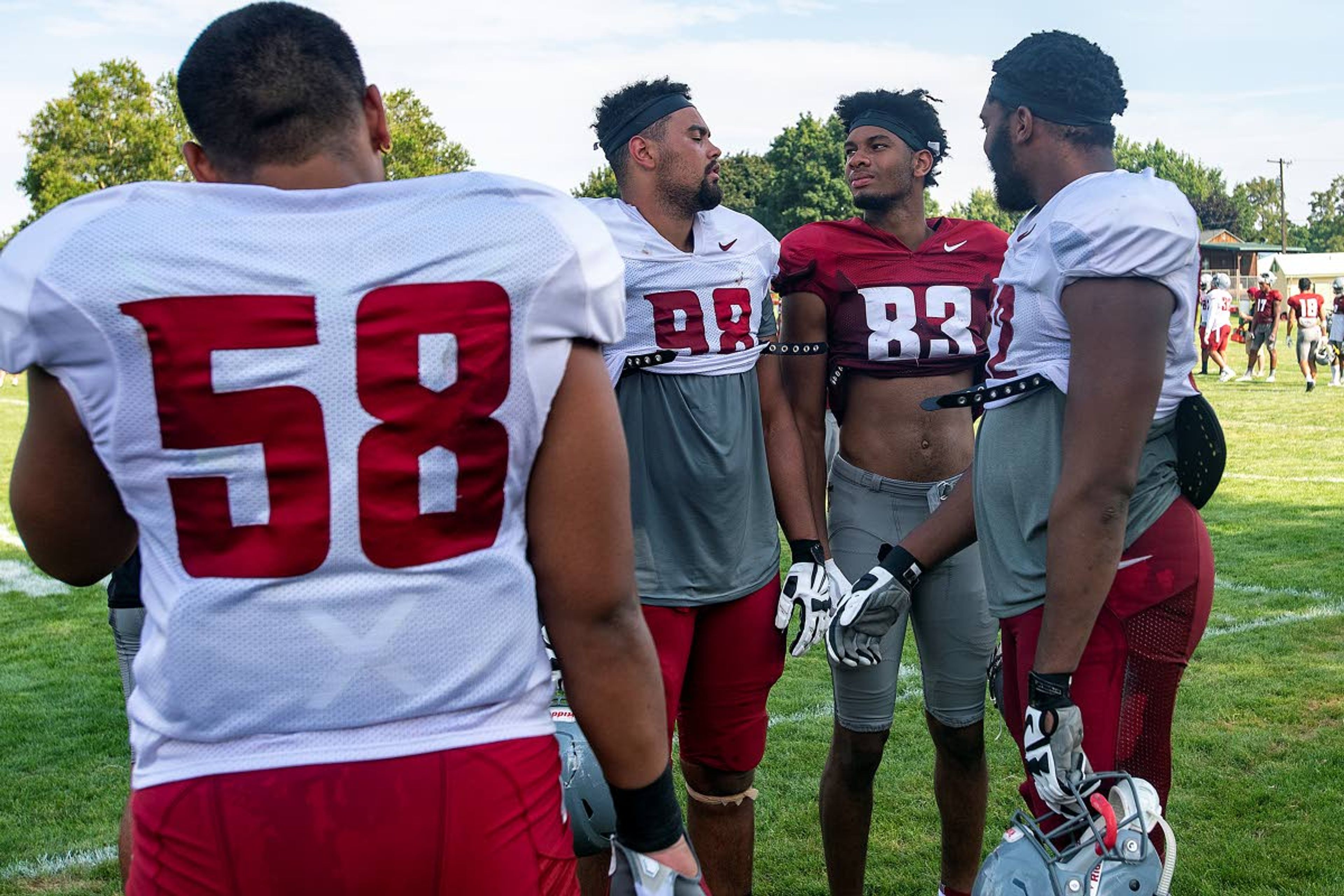 Washington State defensive lineman Dallas Hobbs (98) and receiver Brandon Gray discuss who is taller while special teams players run through drills on Tuesday in Lewiston. According to the roster, Hobbs stands six feet, six inches, while Gray stands six feet, five inches.