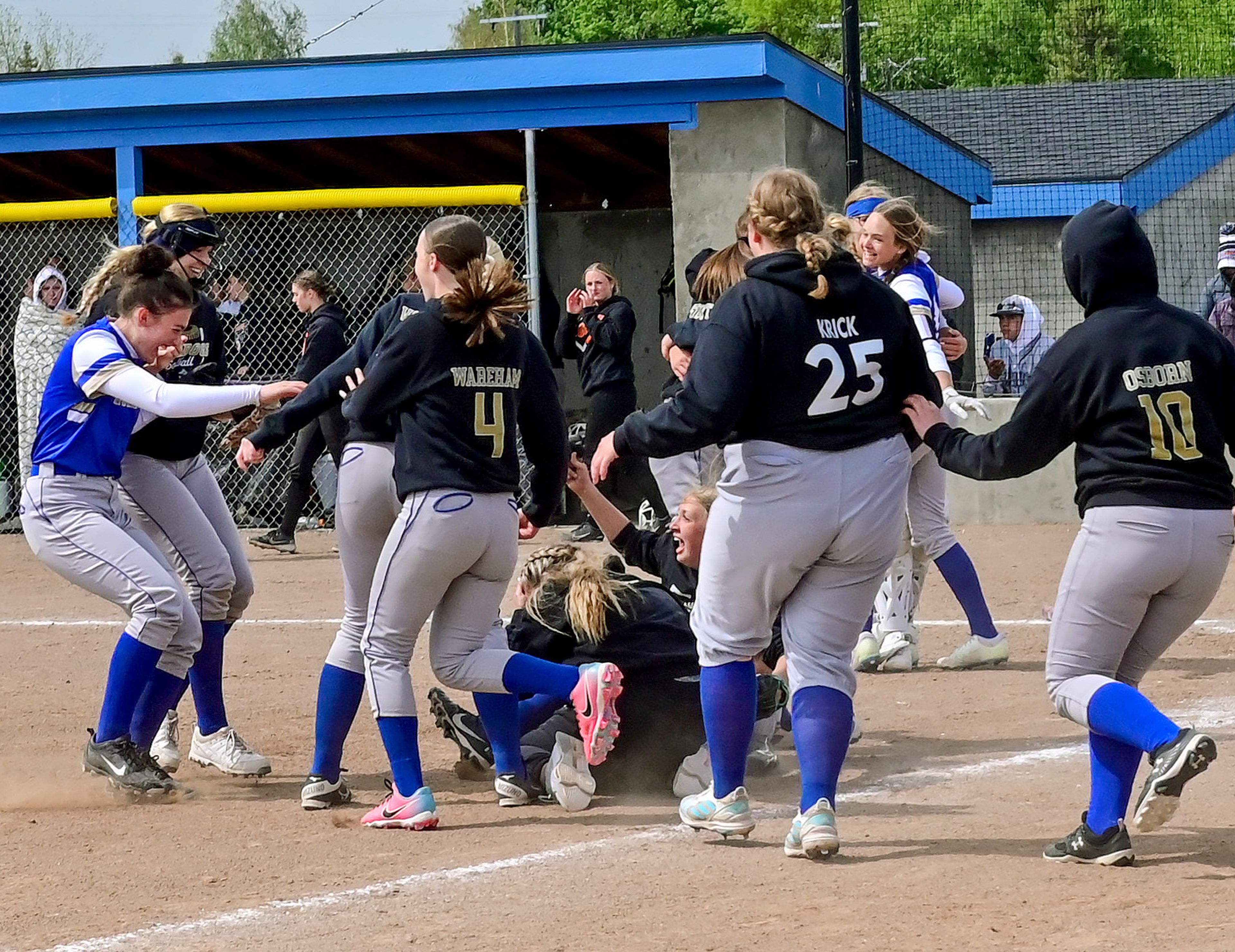 Genesee players run to the dogpile to celebrate winning the Idaho Class 1A state championship game against Kendrick on May 17 in Genesee.