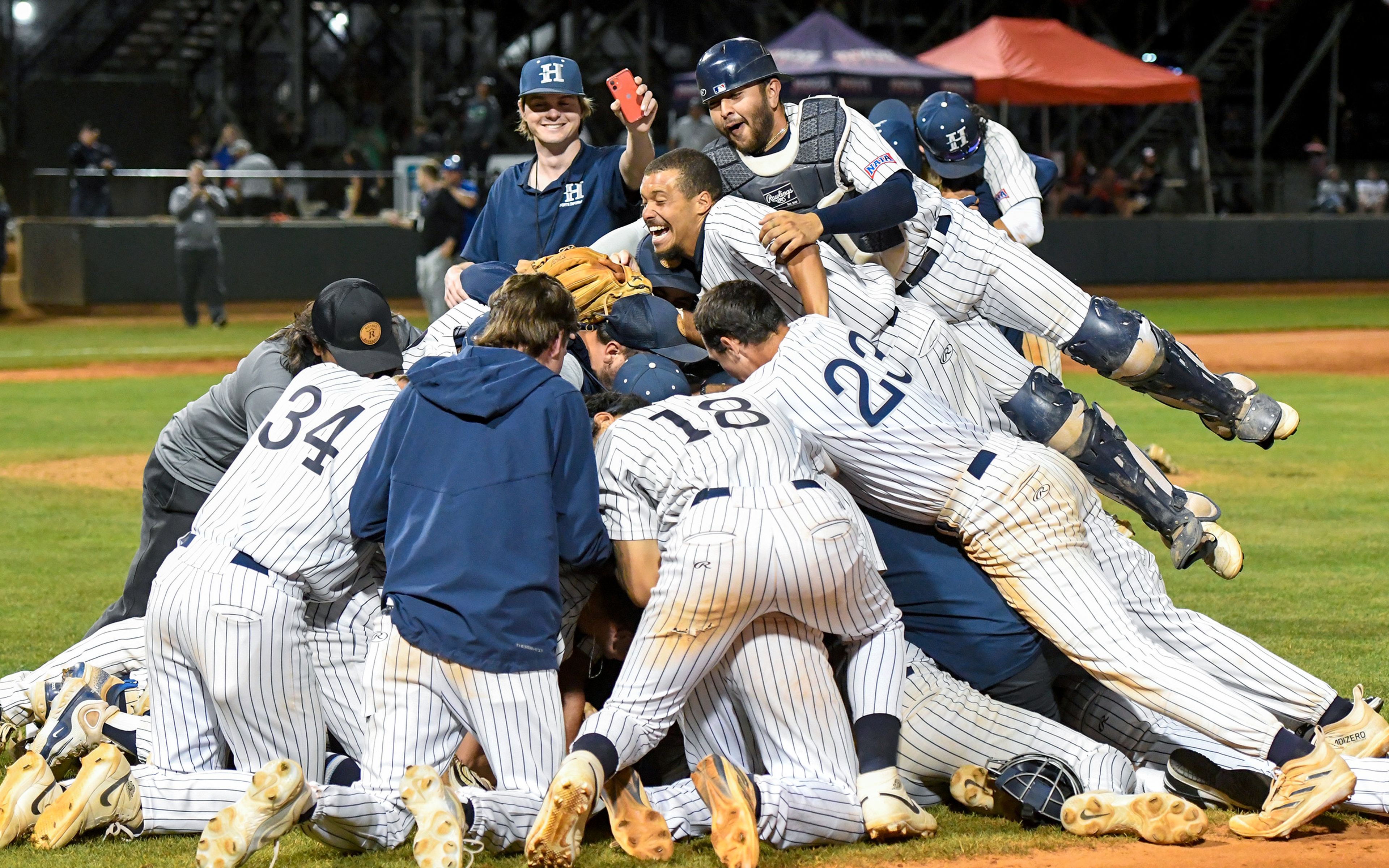 Hope International creates a dogpile near first base after sprinting to the field to celebrate their win over Tennessee Wesleyan for NAIA World Series championship at Harris Field in Lewiston on Friday.