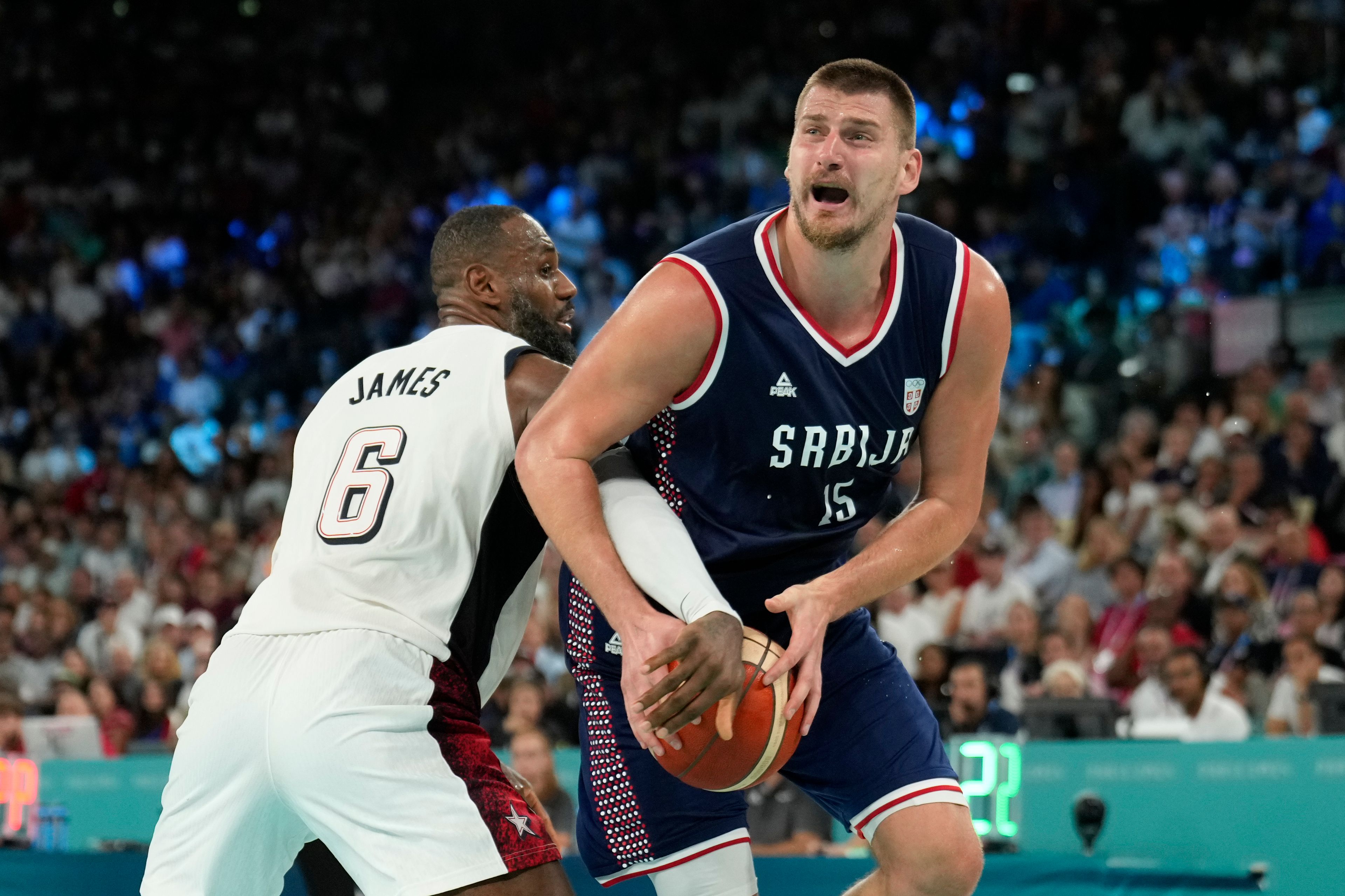 Nikola Jokic (15), of Serbia drives to the basket against United States' LeBron James (6) during a men's semifinals basketball game at Bercy Arena at the 2024 Summer Olympics, Thursday, Aug. 8, 2024, in Paris, France. (AP Photo/Mark J. Terrill)