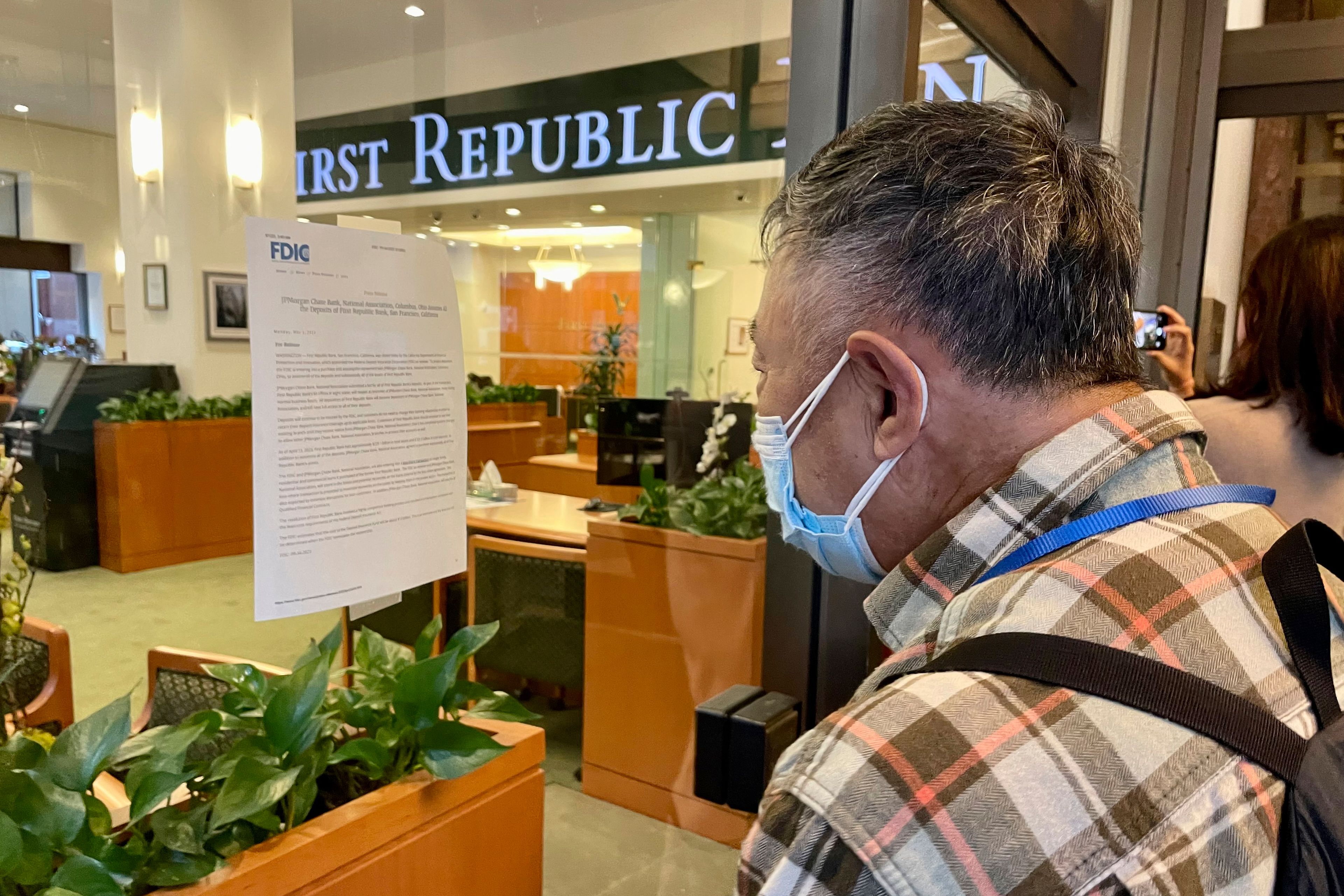 A customer reads an announcement Monday in the window of a First Republic Bank branch by their headquarters in San Francisco.