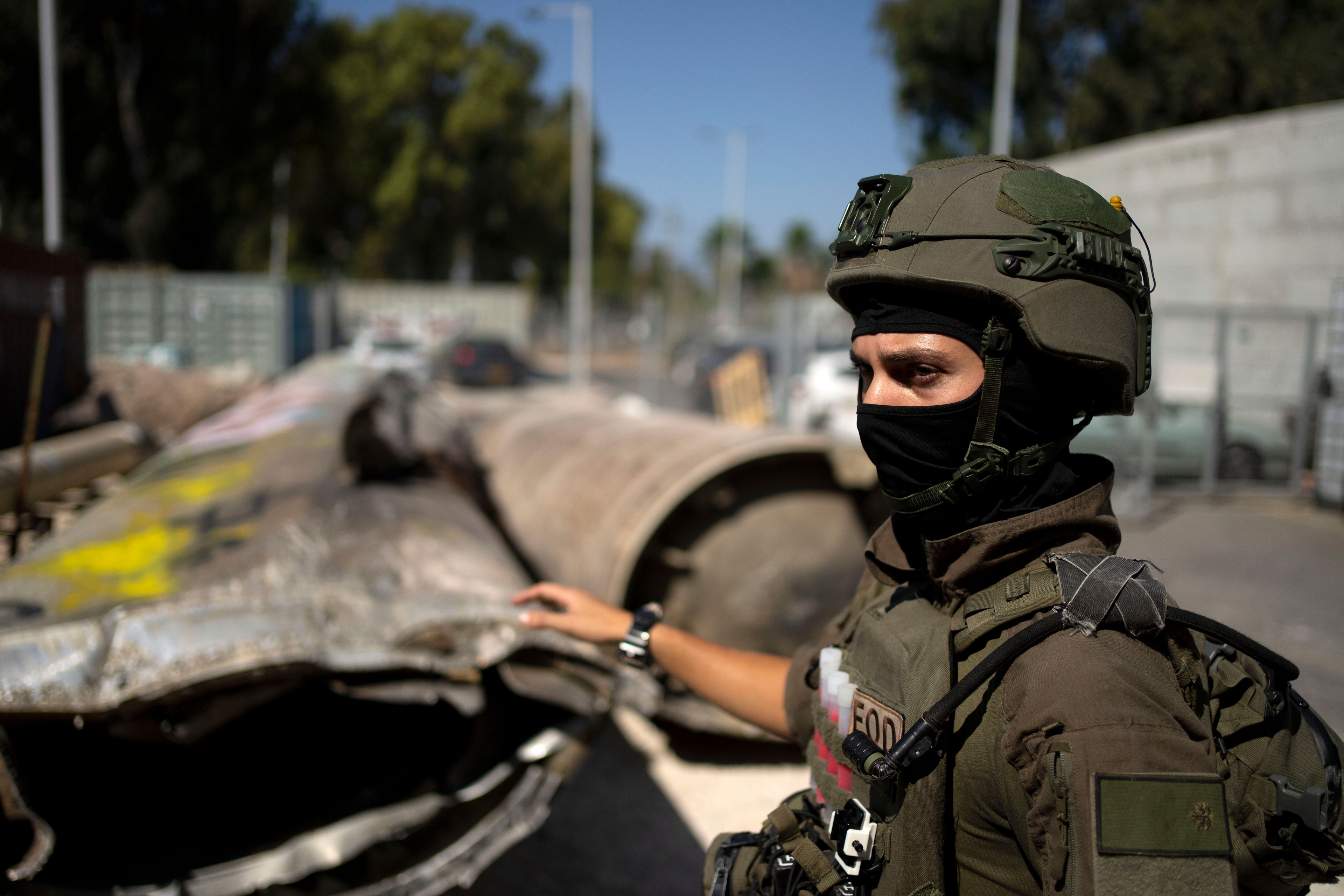 An Israeli soldier from an EOD (explosive ordnance disposal) unit gestures to Iranian ballistic missile components that were fired at Israel, during a government-organized media tour on a base in southern Israel, Wednesday, Oct. 9, 2024. (AP Photo/Maya Alleruzzo)