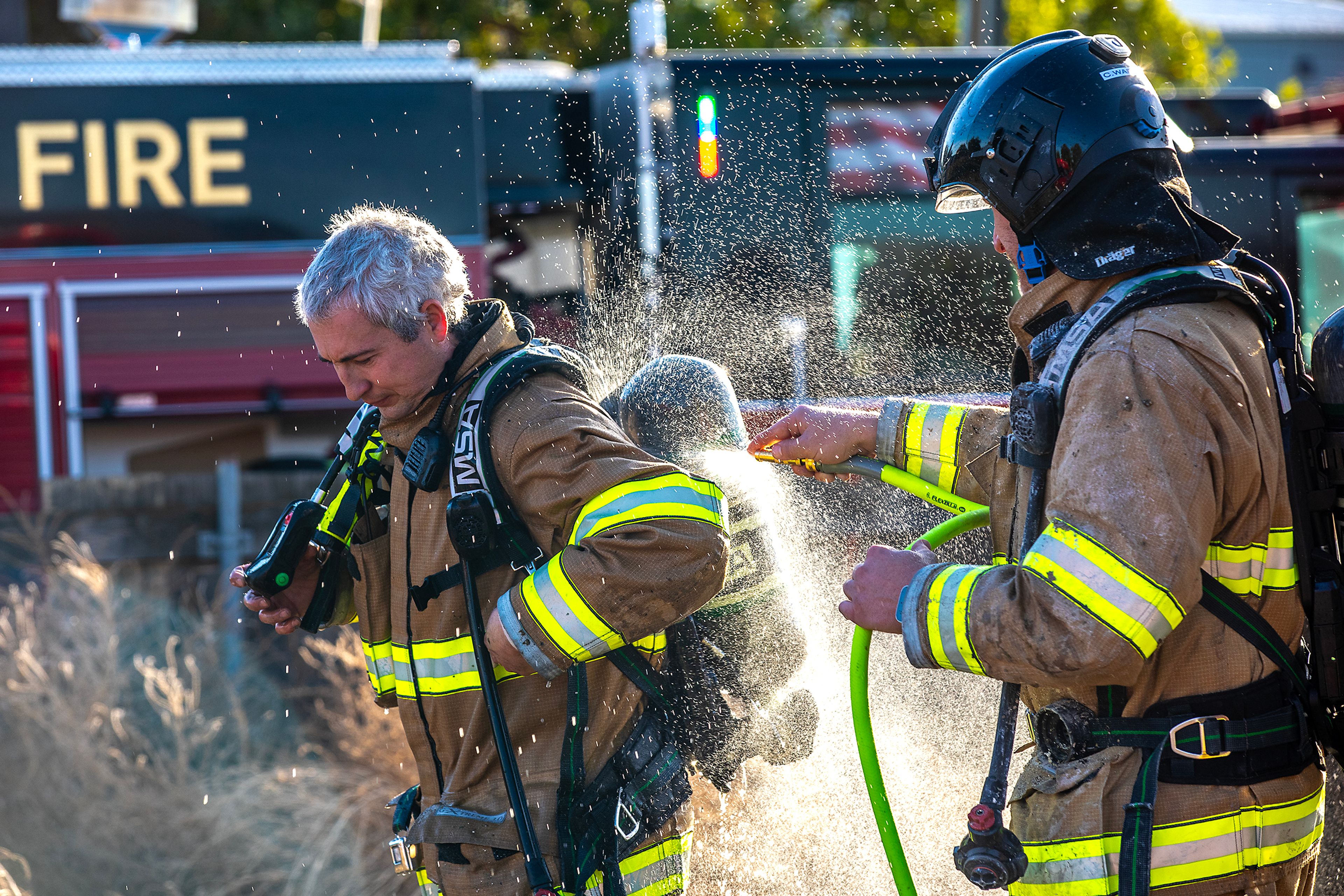 Firefighters spray each other down Thursday off 13th Street in Clarkston.