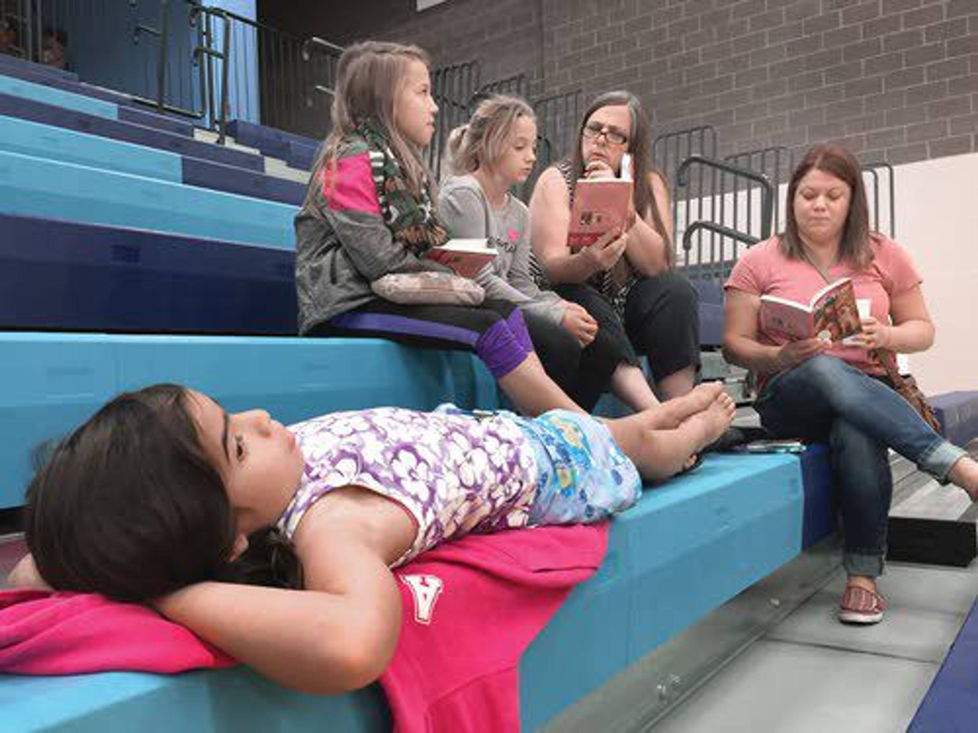 Culdesac fourth-grader Soux Sanford (front) listens along with classmates Hali Anderson and Lexi Reed while school aides Carol Hunt and Staci Smith (right) read about Kaya, a fictional Nez Perce girl. Fourth-grade girls from Culdesac, Lapwai, Kamiah and Orofino received Kaya dolls Friday, donated by the American Girl company.