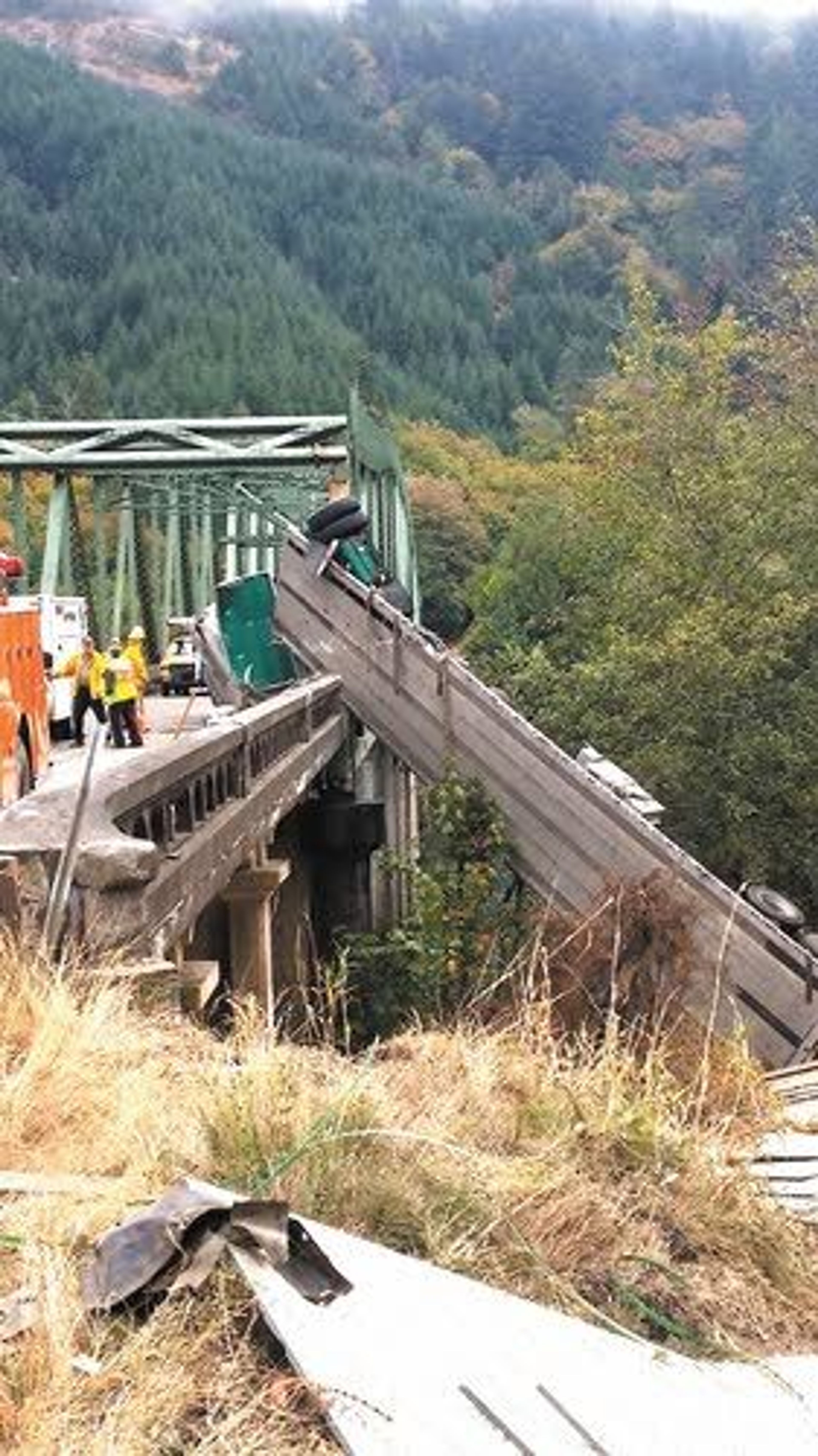 This photo provided by the Oregon State Police shows a truck hanging over a bridge Thursday on the Umpqua River.