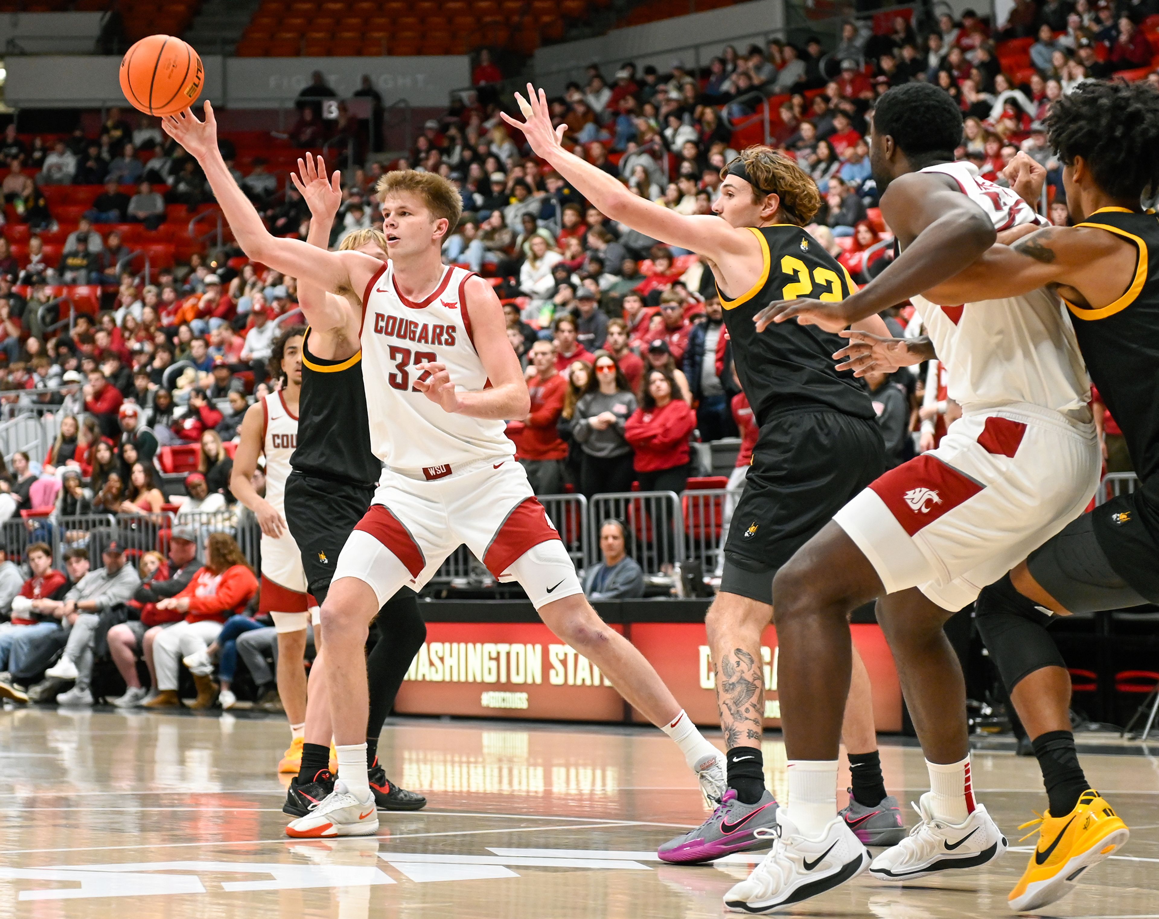 Washington State forward Dane Erikstrup passes the ball while being guarded by Idaho forward Tyler Linhardt at the Battle of the Palouse game at Beasley Coliseum in Pullman.