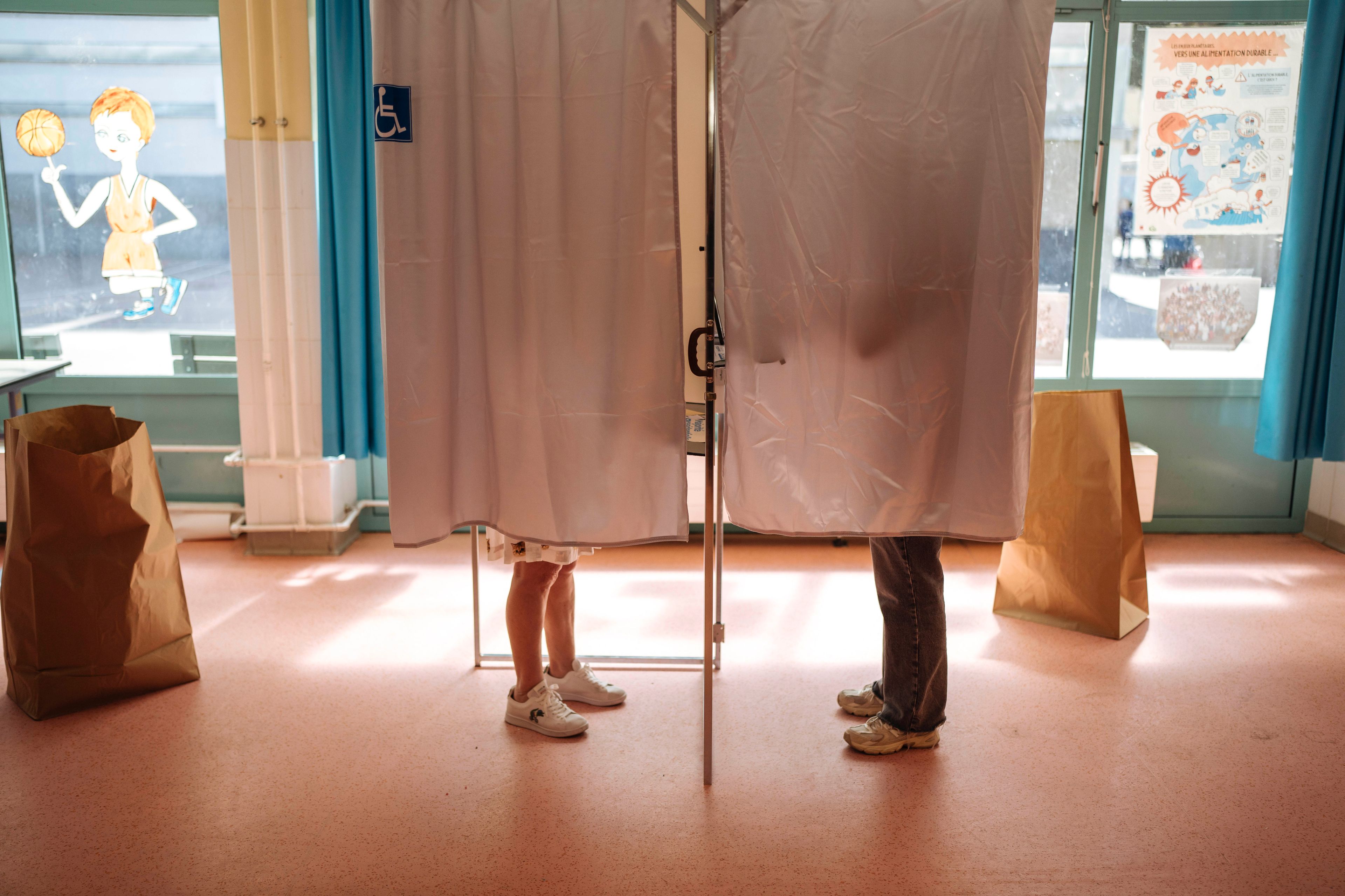 People cast their votes in the voting booth, during the European election, Sunday, June 9, 2024 in Paris. Polling stations opened across Europe on Sunday as voters from 20 countries cast ballots in elections that are expected to shift the European Union's parliament to the right and could reshape the future direction of the world's biggest trading bloc.