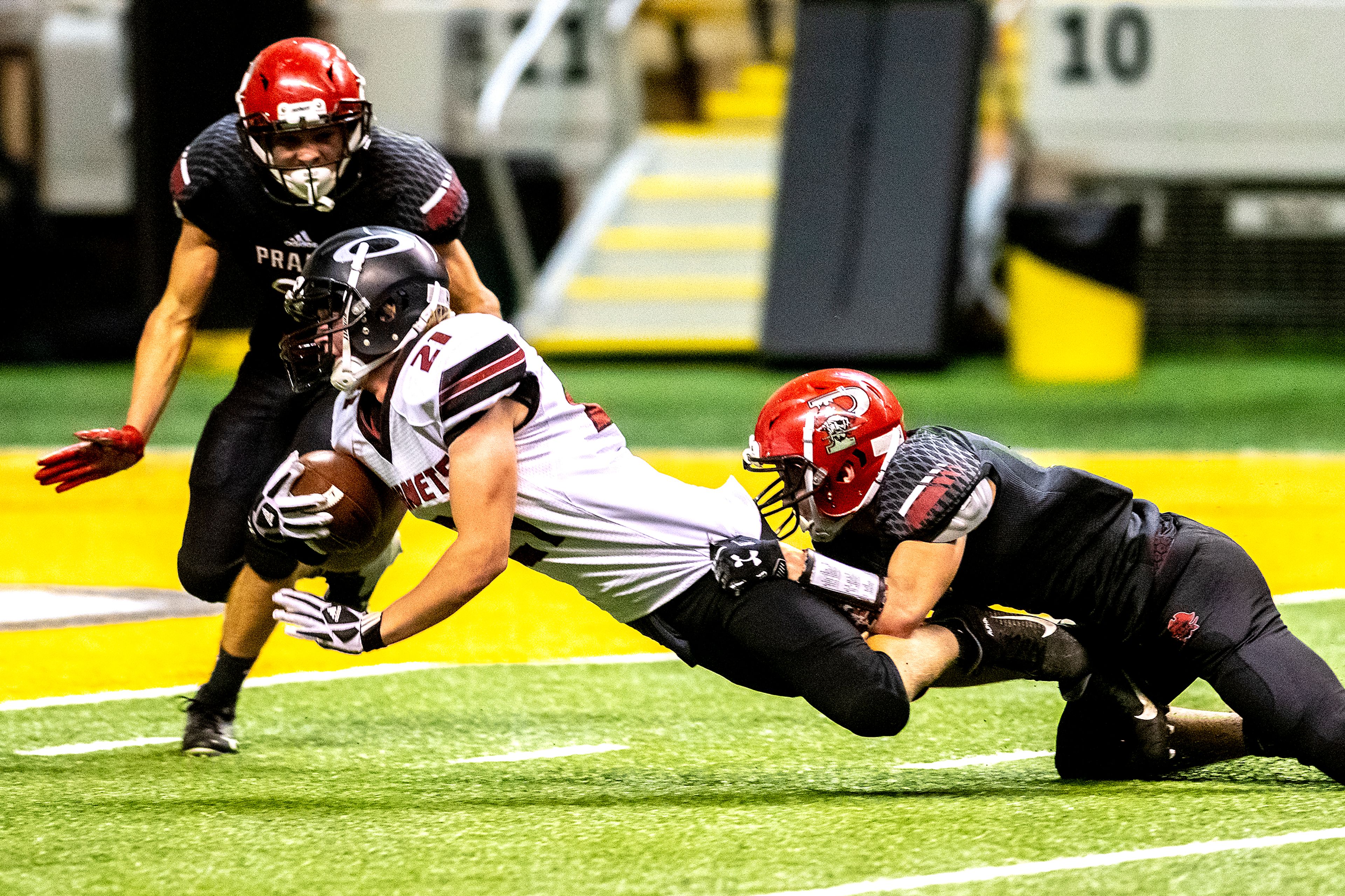 Prairie’s Cole Schlader latches onto the legs of Oakley’s Robert Wybenga to bring him down before the end zone. The Prairie Pirates lost to the Oakley Hornets 42-40 in the Class 1A Division O state semifinal football game at the Kibbie Dome in Moscow on Friday.