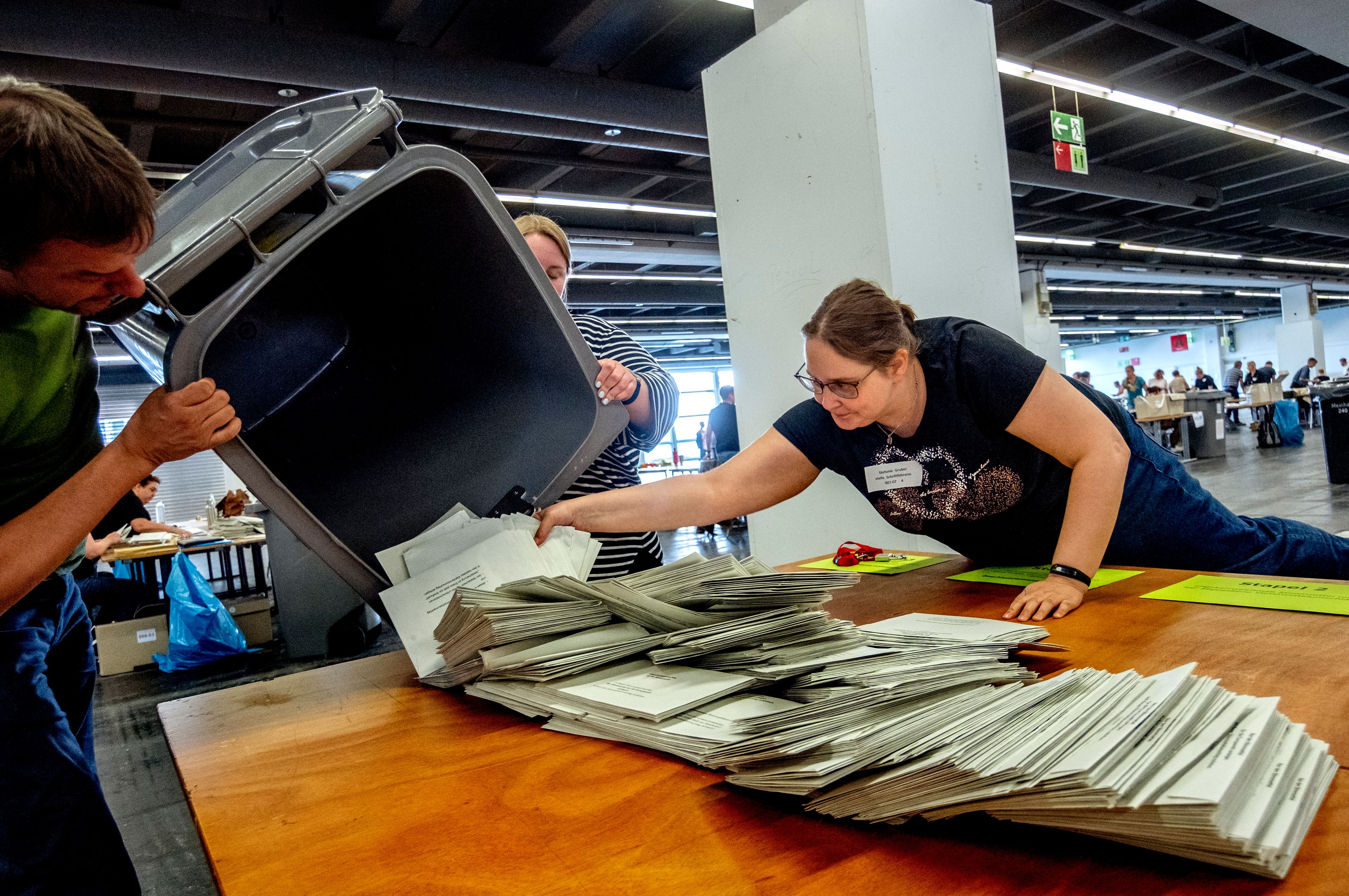 Elections helpers empty a bin to count the postal ballots for the European elections in a hall of the fair sound in Frankfurt, Germany, Sunday, June 9, 2024.