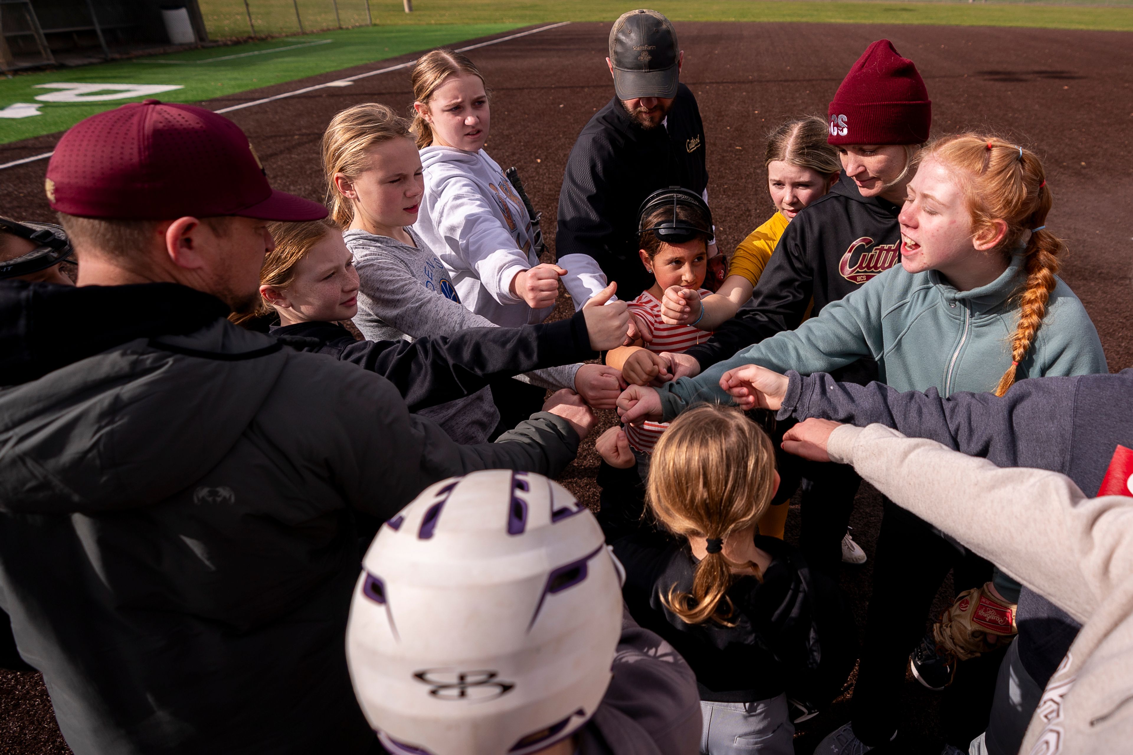 The Cutthroats 10u and 12u softball teams huddle together at the end of their practice on Saturday at P1FCU Field next to Hereth Park in the Lewiston Orchards.