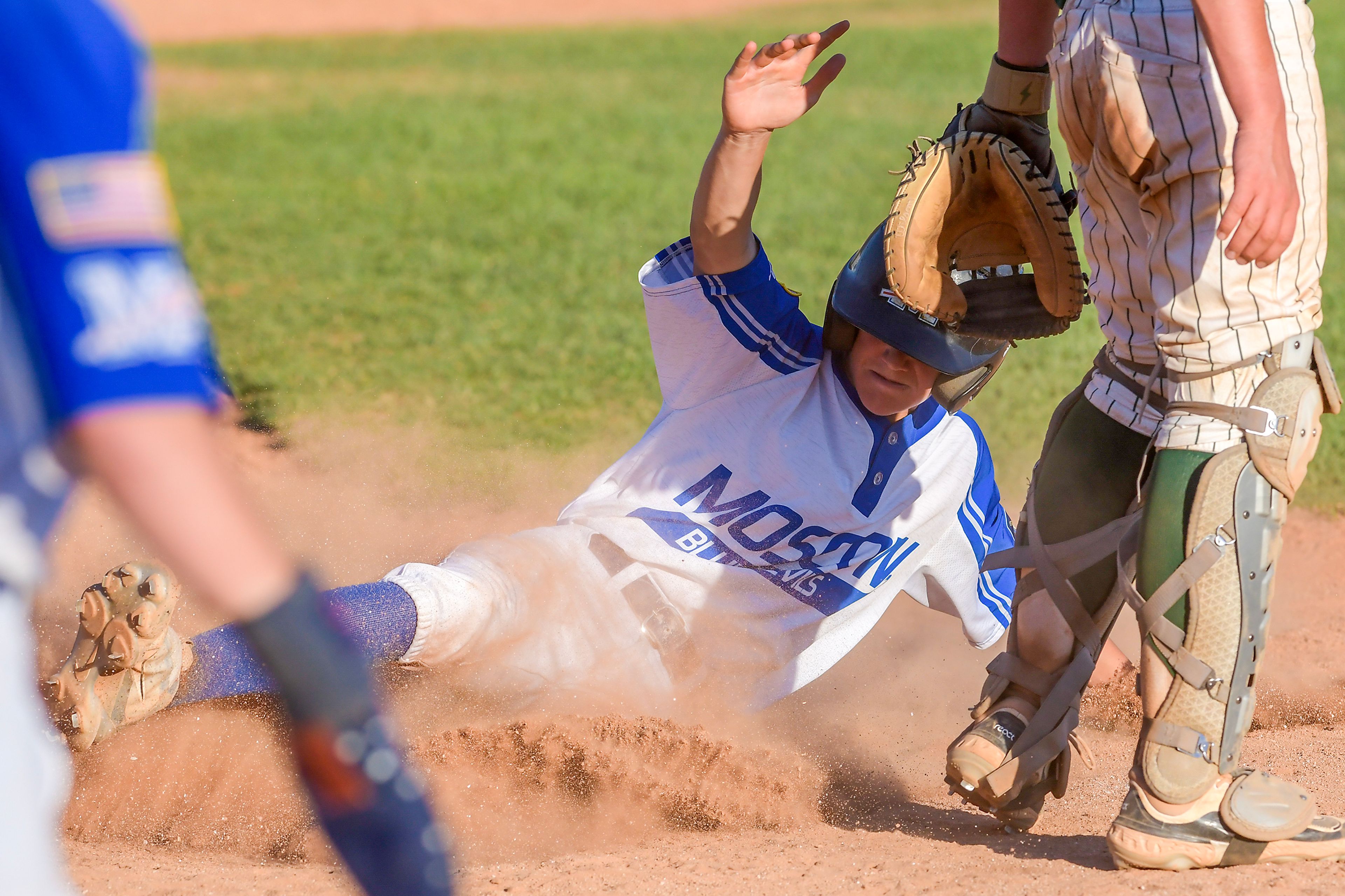 The Moscow Blue Devils' Jackson Banks slides into home against Lewis-Clark Cubs in a game of the Clancy Ellis Tournament on Saturday at Harris Field in Lewiston.