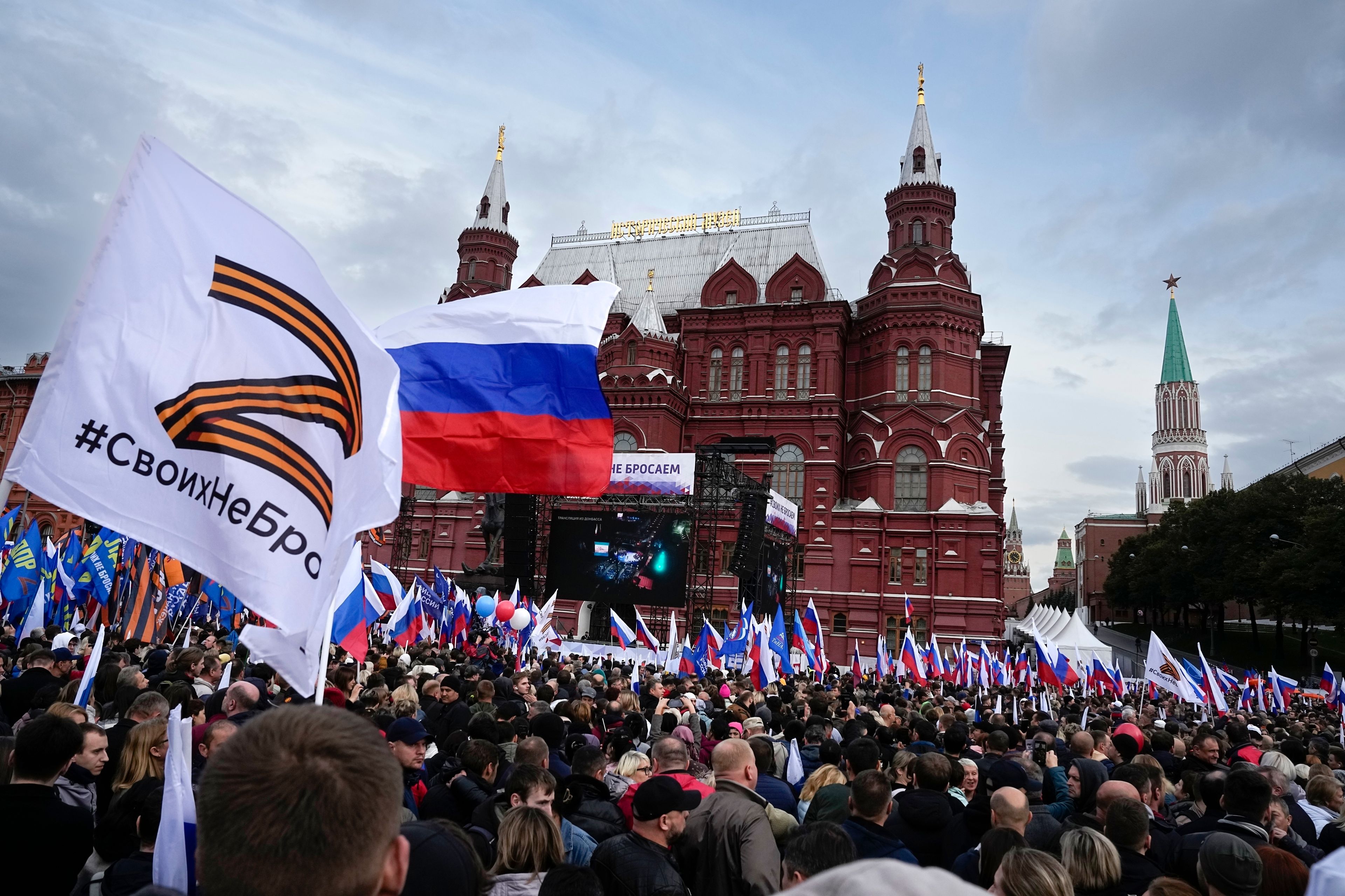 FILE - Demonstrators hold Russian state flags and flags with with the letter Z, which has become a symbol of the Russian military, and a hashtag reading "We don't abandon our own" during the action "We do not abandon our own" to support the referendum, on Manezhnaya Square near the Kremlin and Red Square with the Historical Museum in the background in Moscow, Russia, Friday, Sept. 23, 2022. In Russia, history has long become a propaganda tool used to advance the Kremlin's political goals. In an effort to rally people around the flag, the authorities have sought to magnify the country's past victories while glossing over the more sordid chapters of its history. (AP Photo/Alexander Zemlianichenko, File)