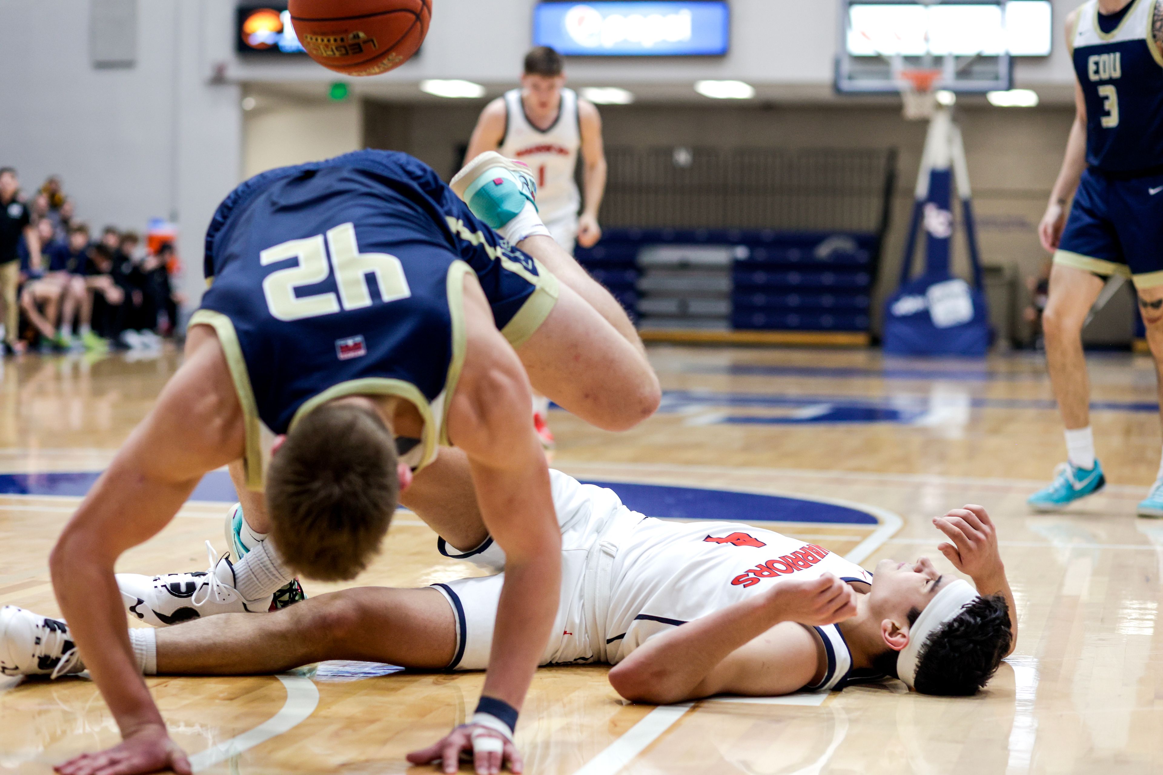 Lewis-Clark State guard Silas Bennion lays on the floor as Eastern Oregon guard/forward Adam Orr trips over him in a scramble for the ball during a Cascade Conference game Friday at Lewis-Clark State College.