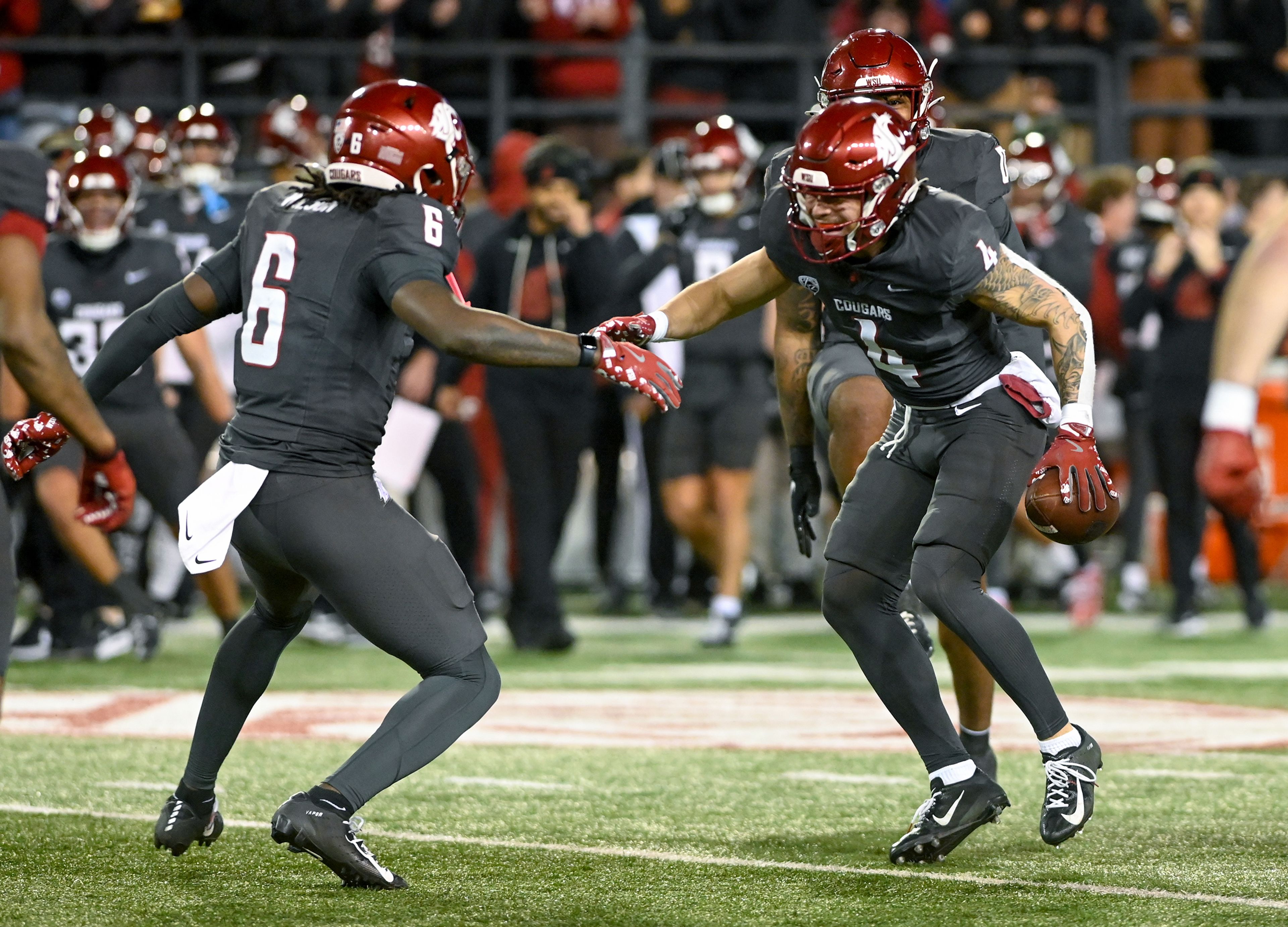 Washington State defensive back Adrian Wilson (6) and Washington State defensive back Kapena Gushiken (4) celebrate an interception by Gushiken Saturday during a game against Utah State at Gesa Field in Pullman.